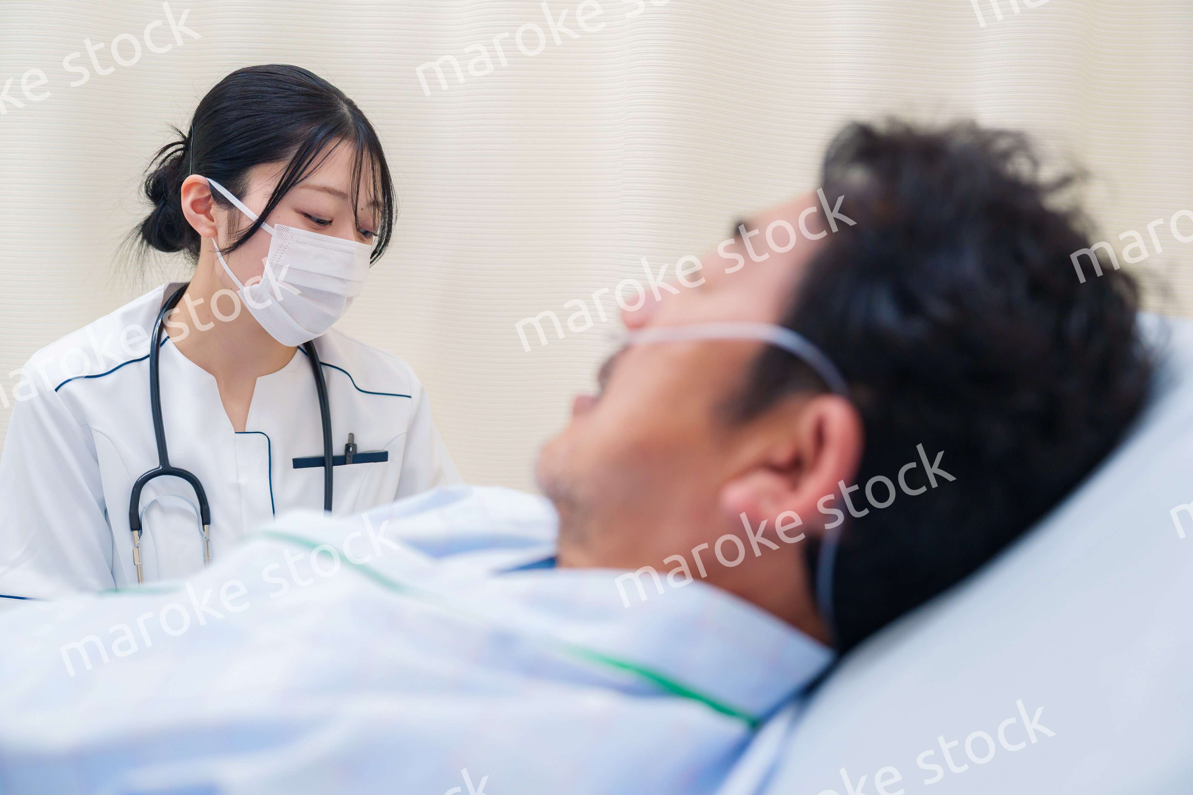 病棟で入院患者のケアをする医療従事者の女性