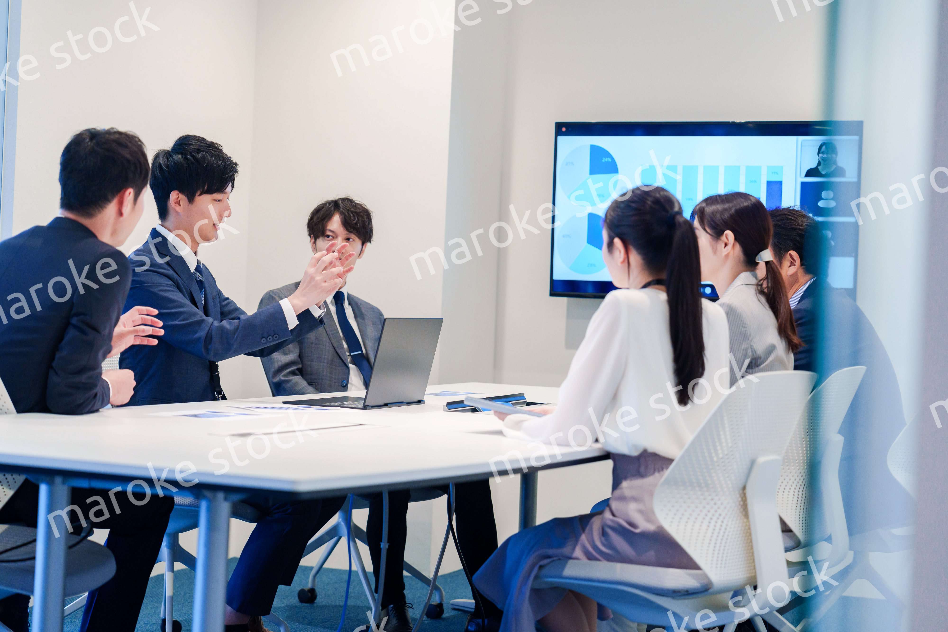 スーツを着て会議で話す若い男性