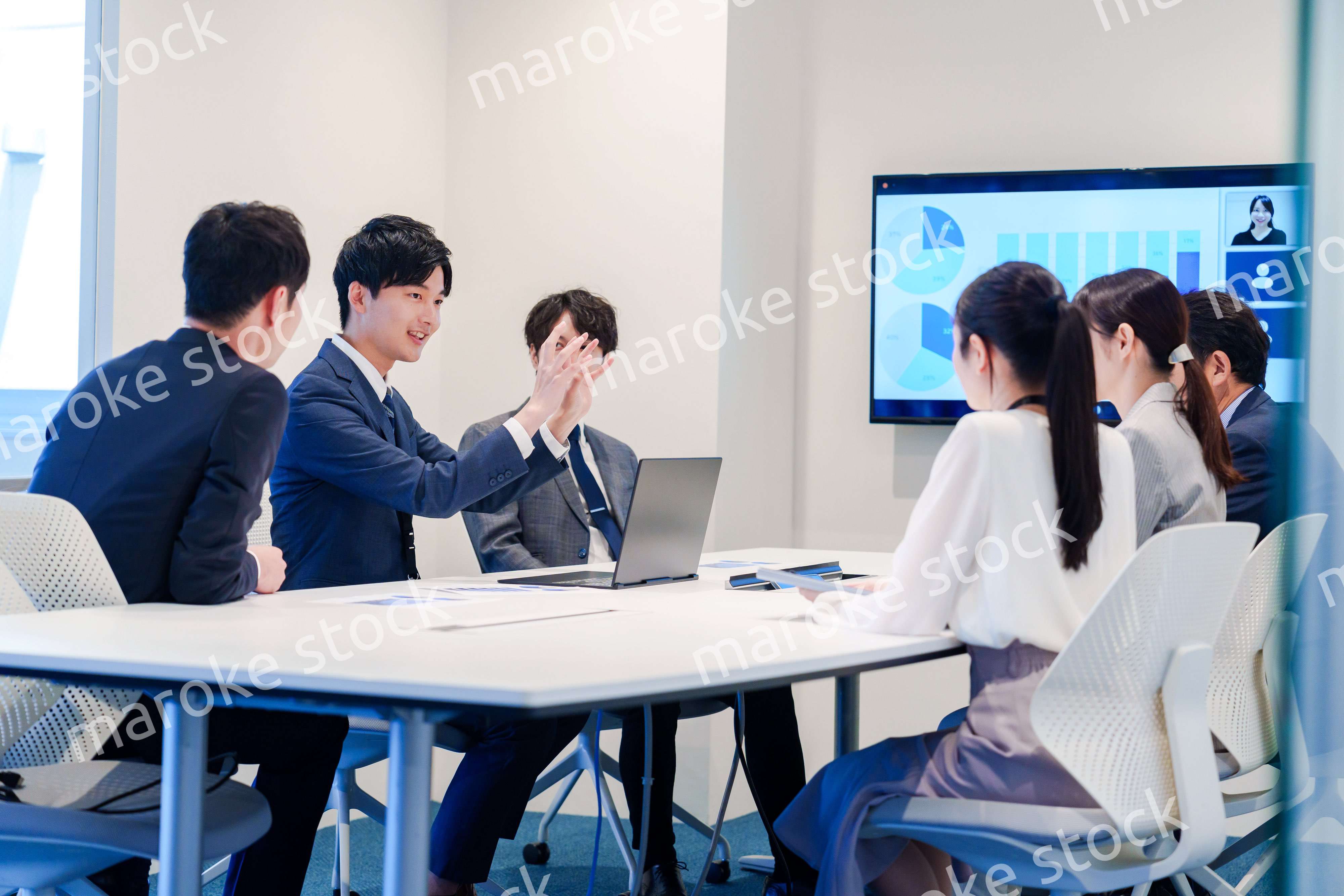 スーツを着て会議で話す若い男性