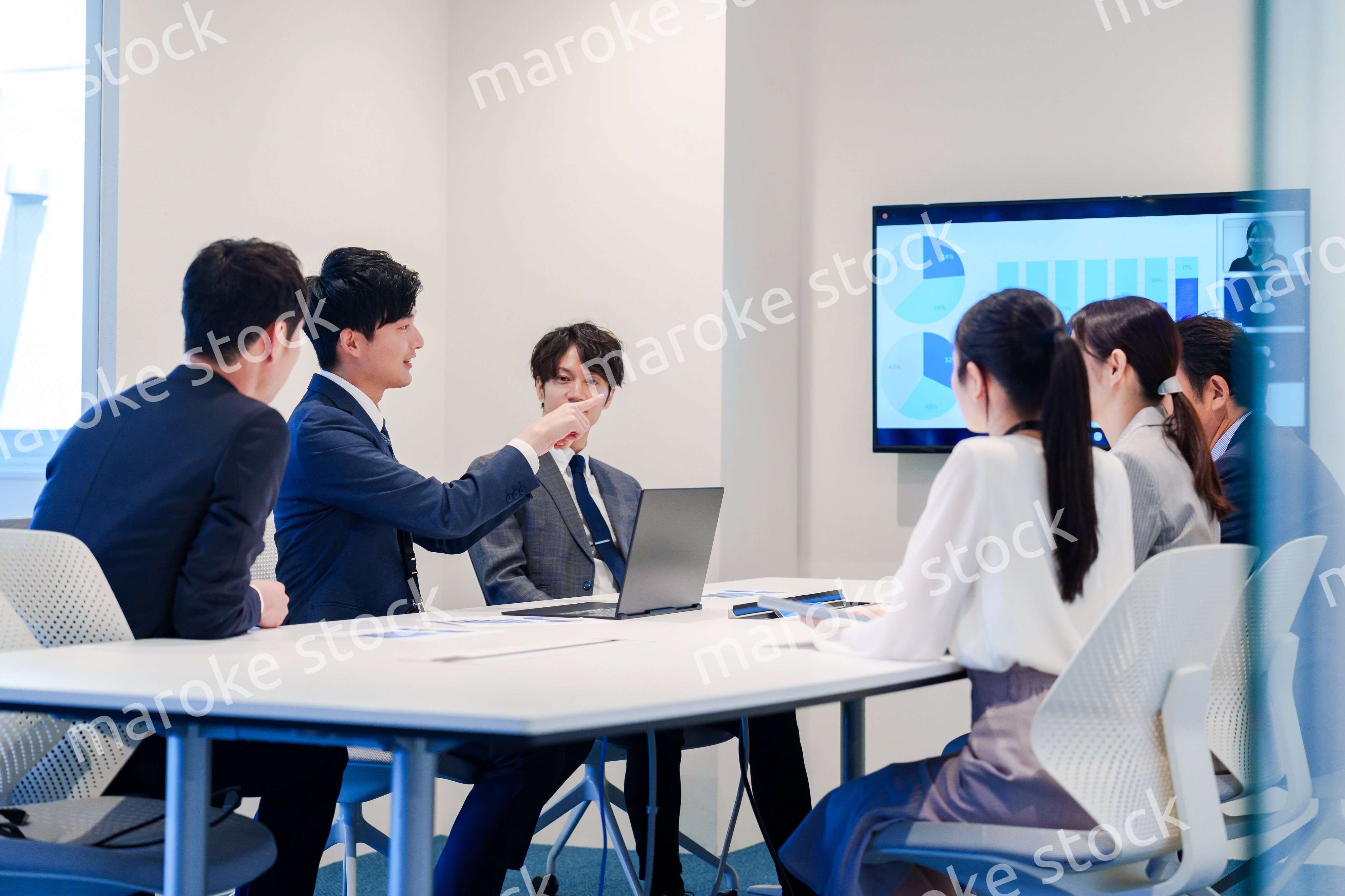 スーツを着て会議で話す若い男性