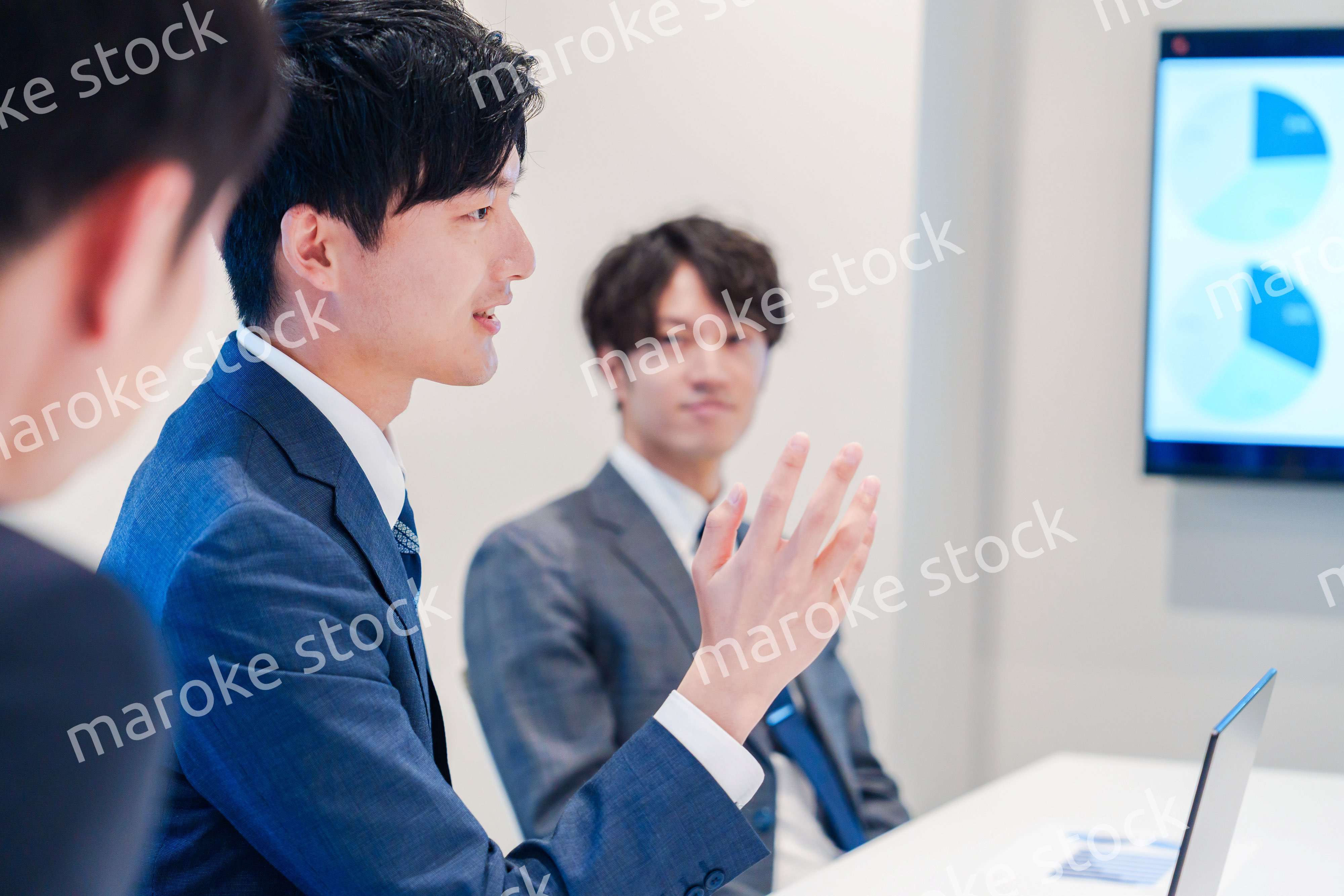 ミーティングで発言をする若い男性ビジネスマン