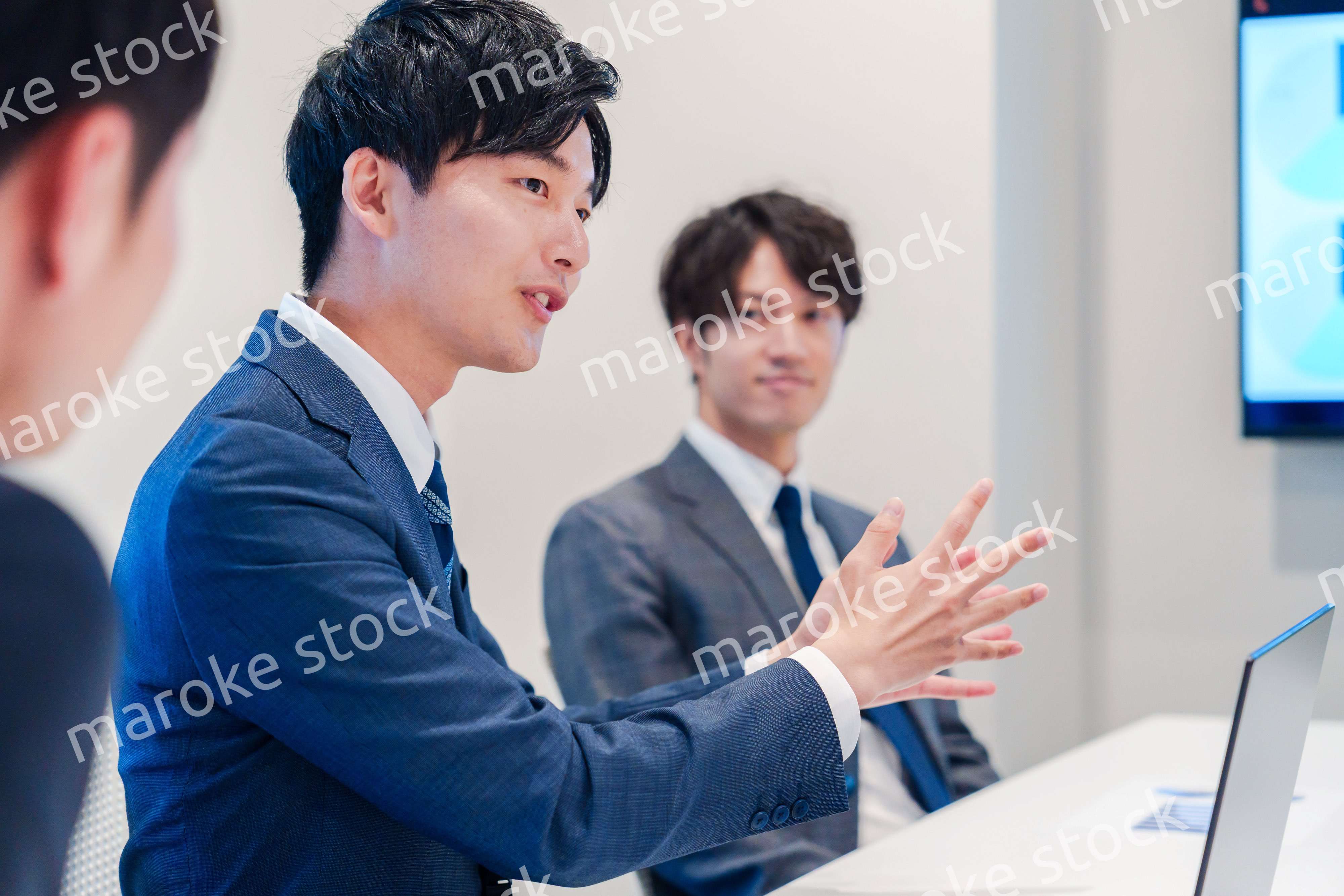 ミーティングで発言をする若い男性ビジネスマン