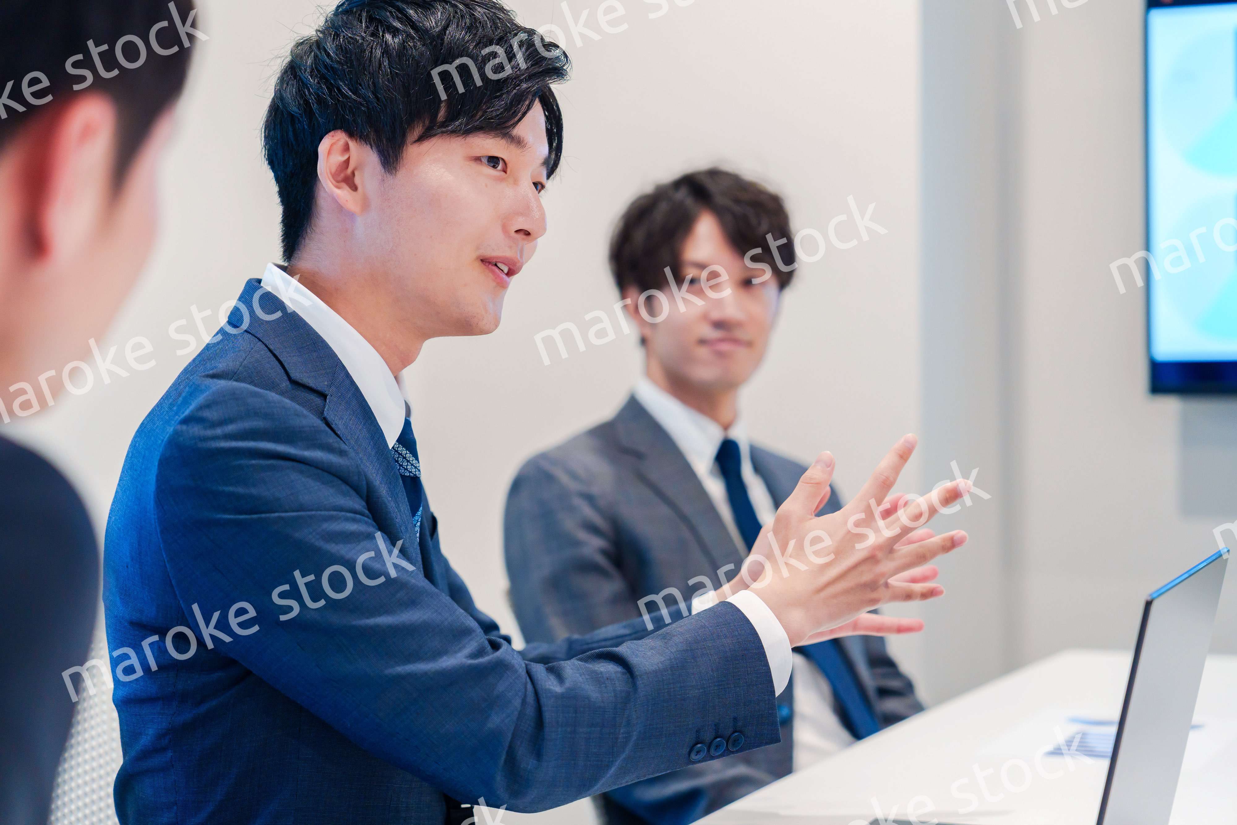 ミーティングで発言をする若い男性ビジネスマン