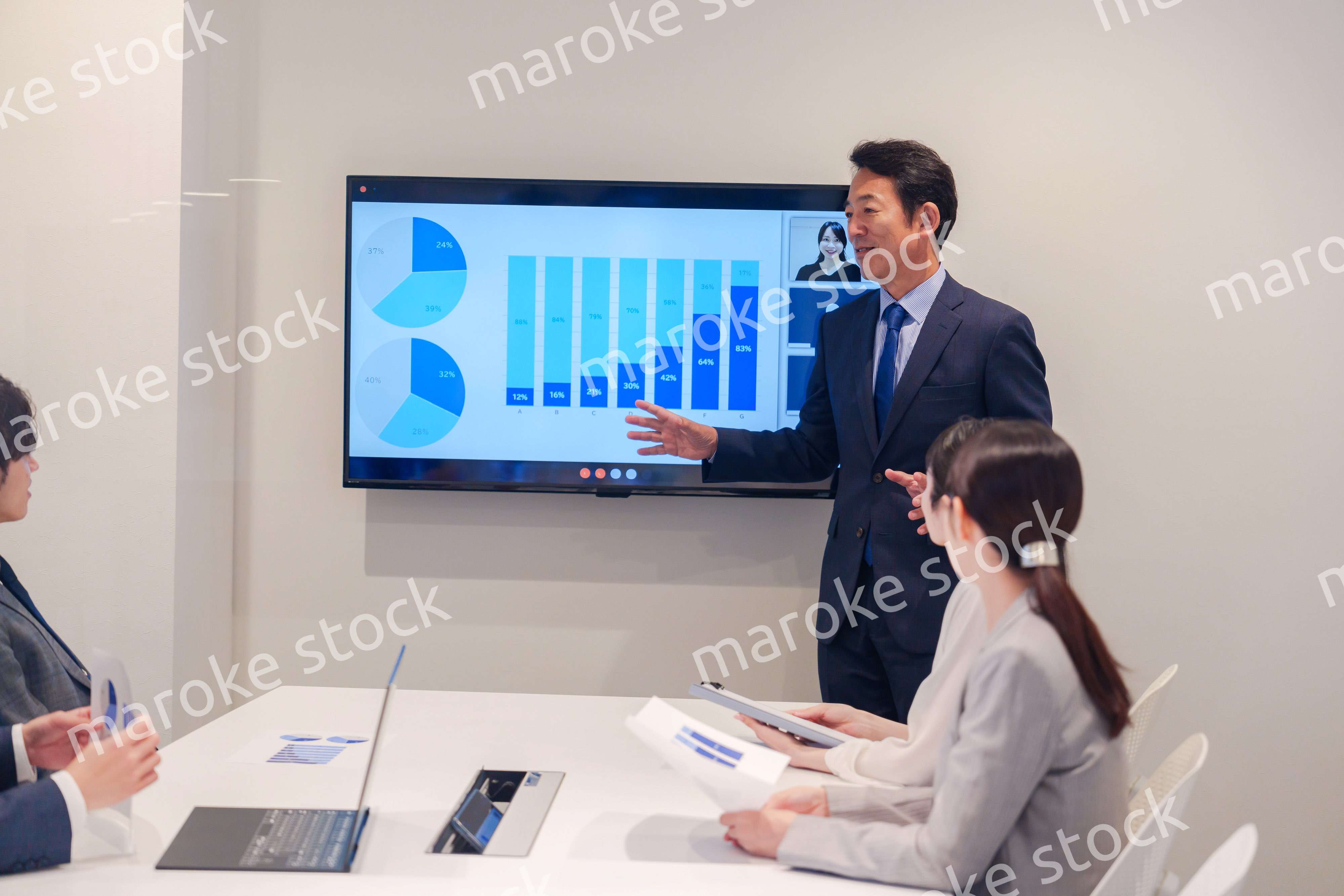 会議で資料を見ながらプレゼンをする中年のオフィスワーカー