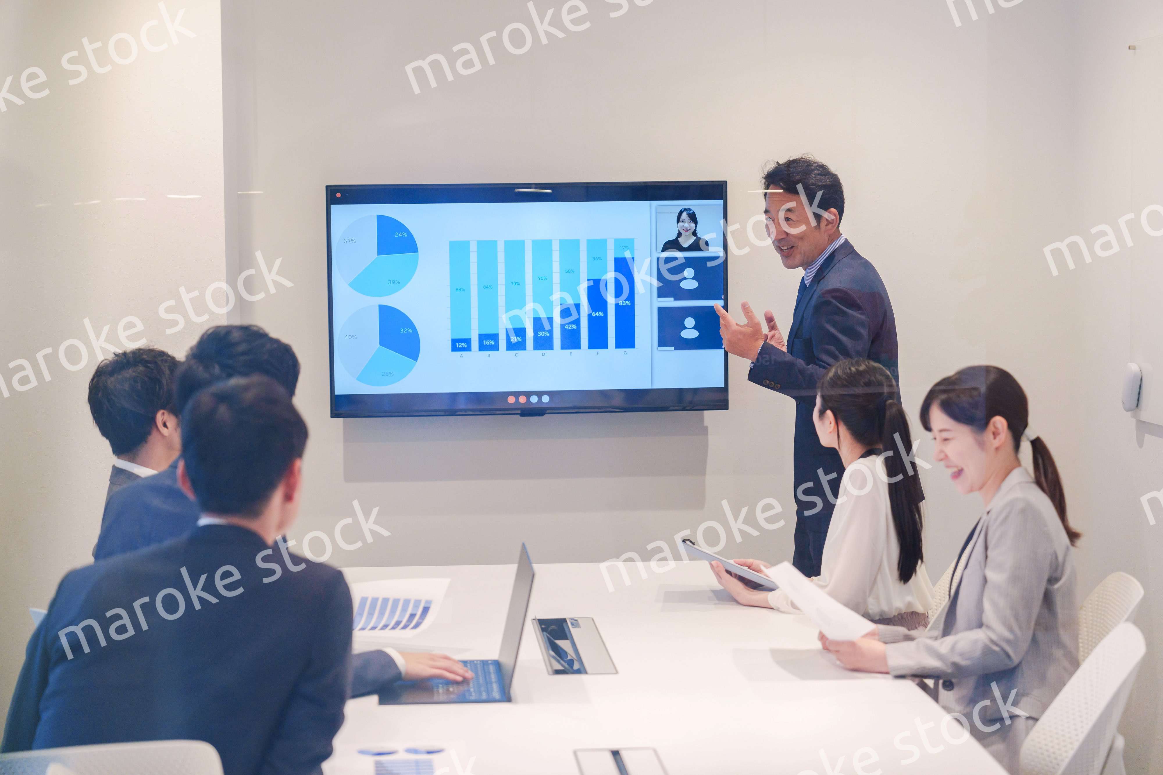 会議で資料を見ながらプレゼンをする中年のオフィスワーカー