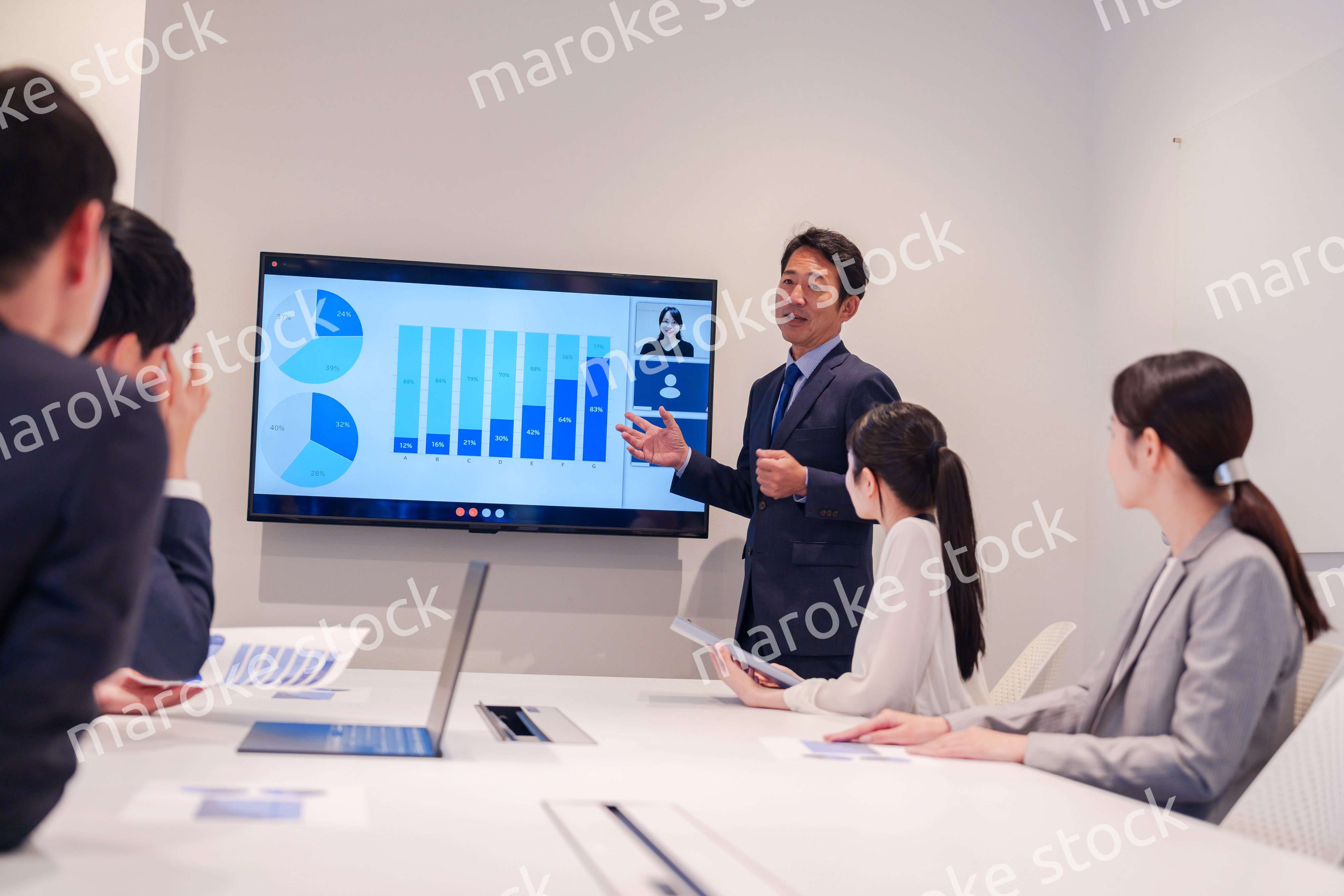 会議で資料を見ながらプレゼンをする中年のオフィスワーカー