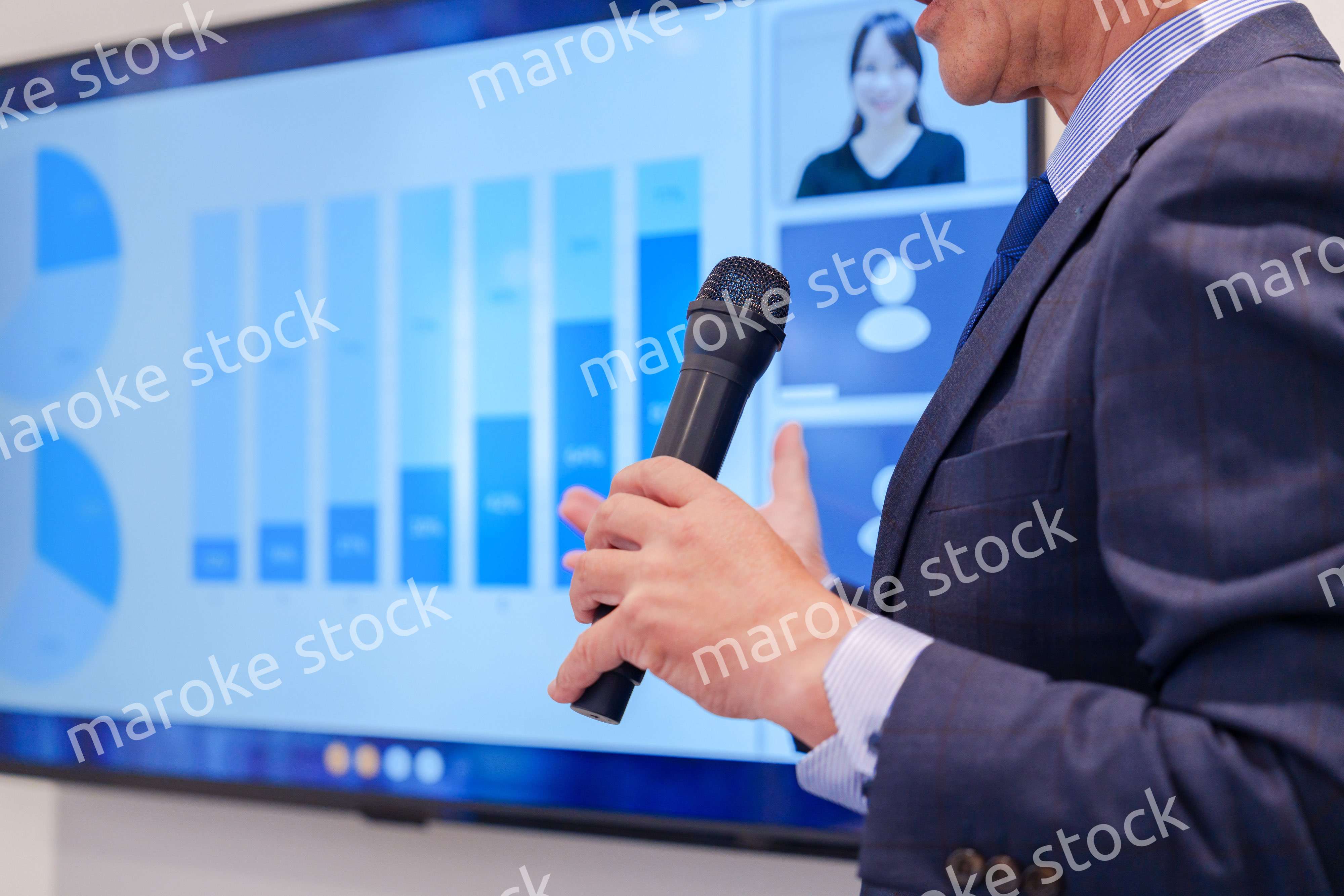 会議で資料を見ながらプレゼンをする中年のオフィスワーカー