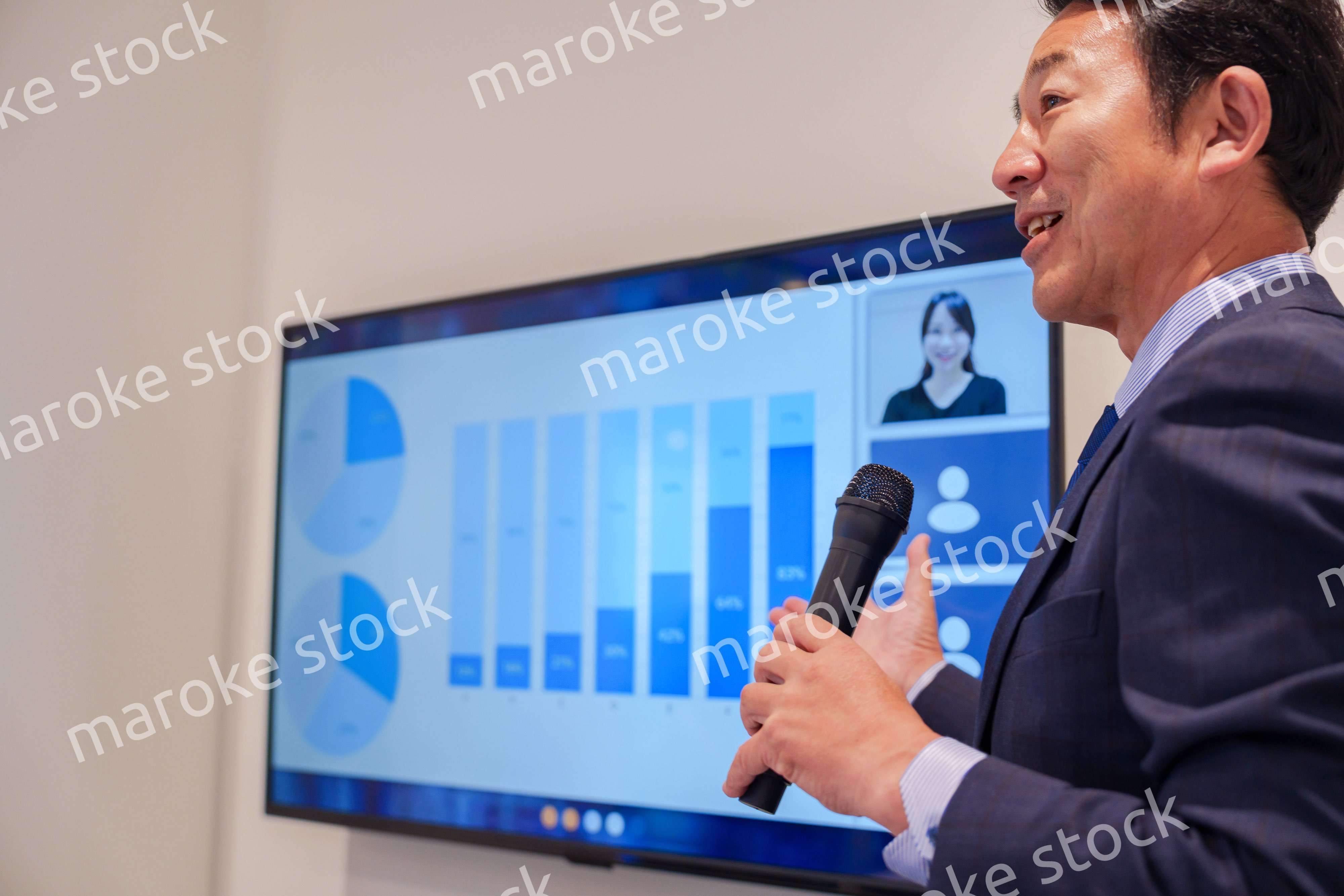 会議で資料を見ながらプレゼンをする中年のオフィスワーカー