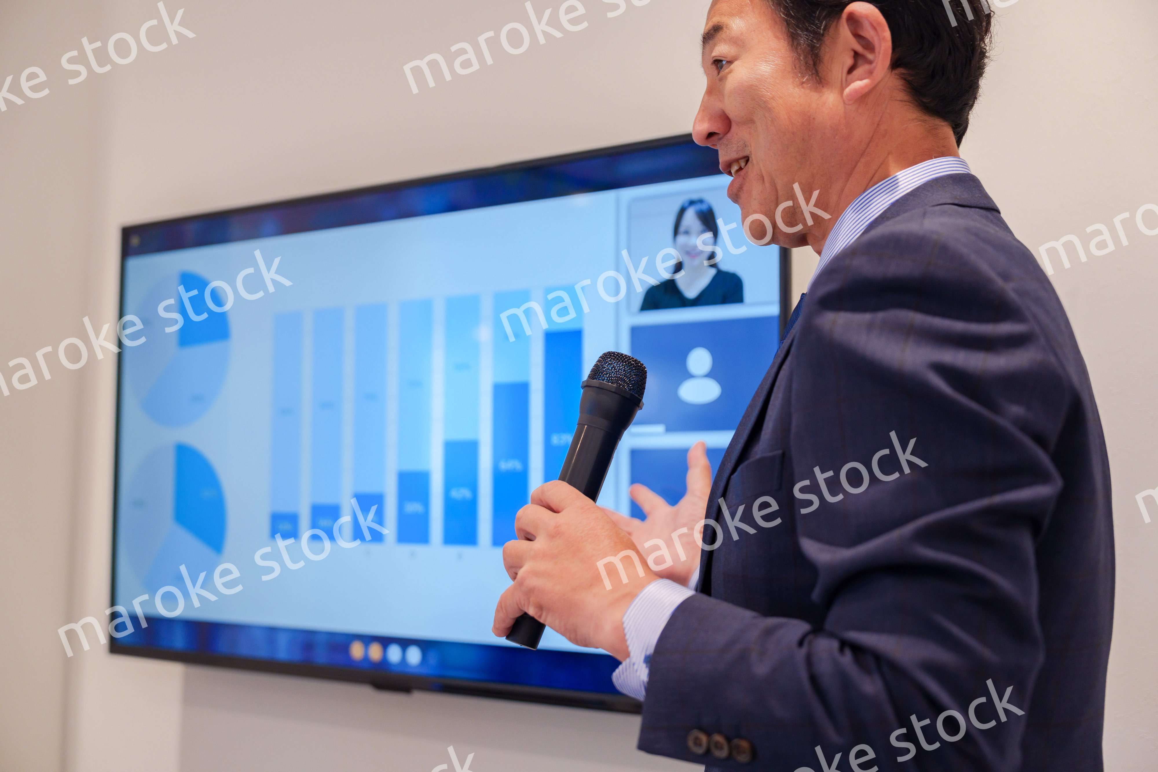 会議で資料を見ながらプレゼンをする中年のオフィスワーカー