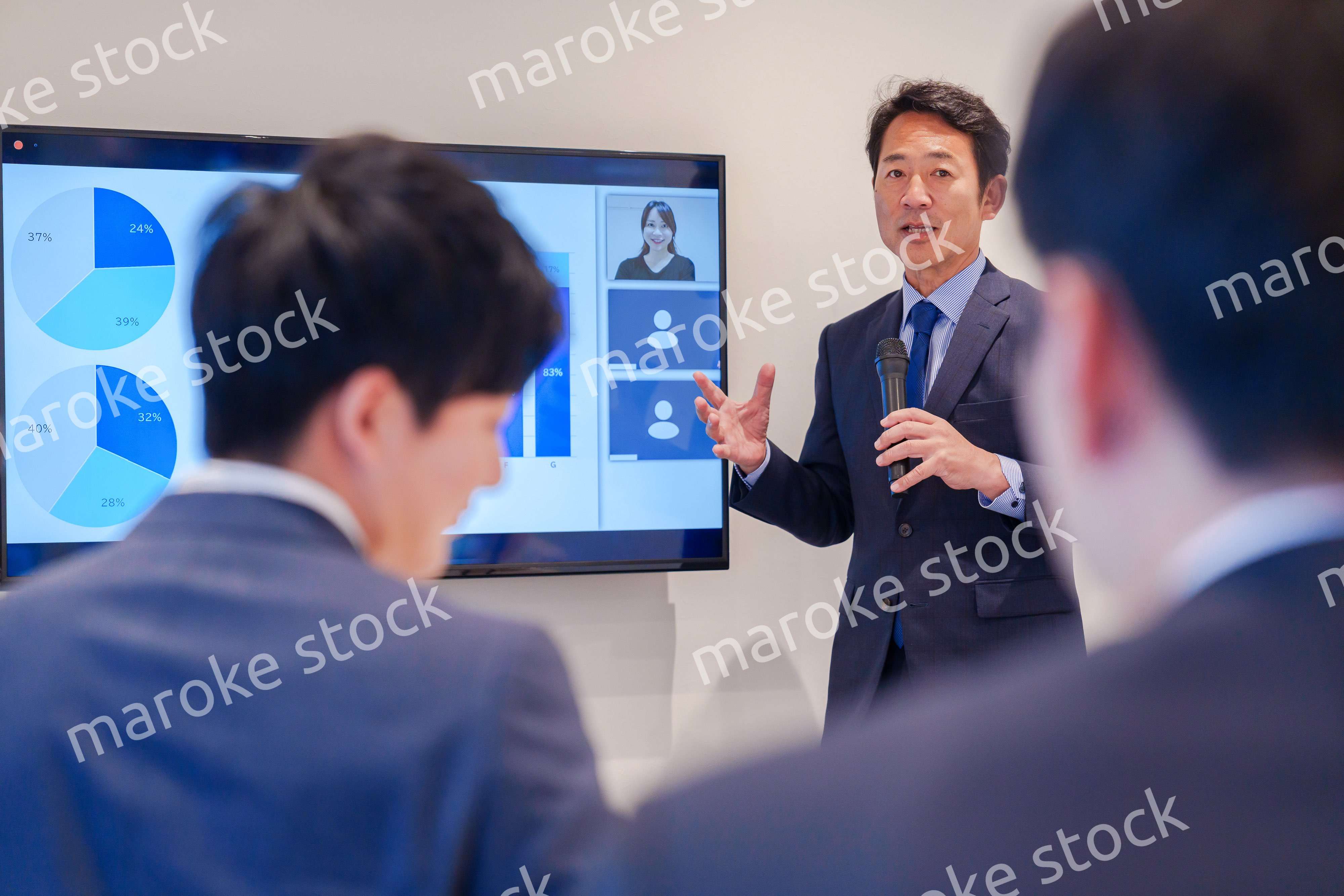 会議で資料を見ながらプレゼンをする中年のオフィスワーカー