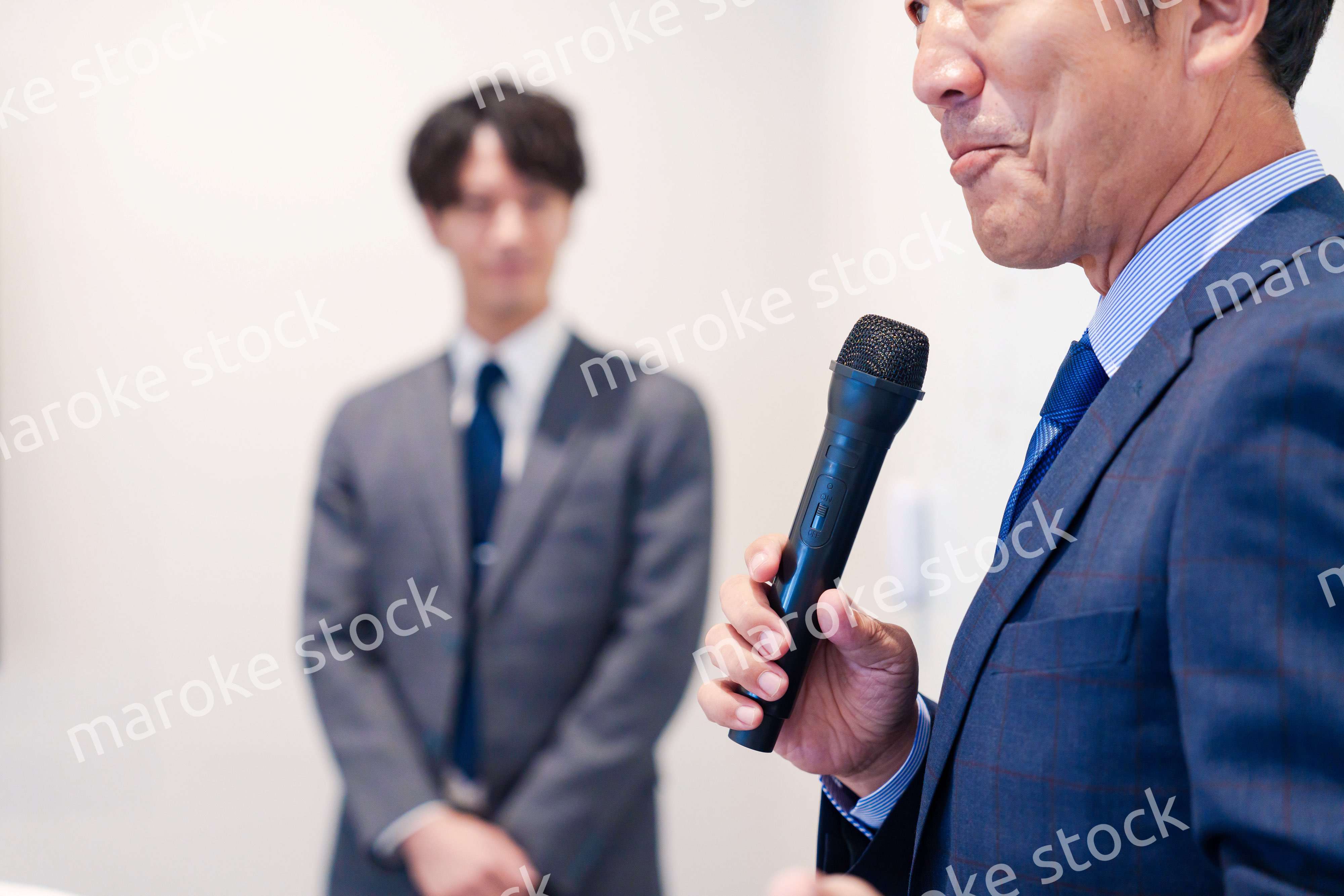 マイクを使って演説をする中年の男性