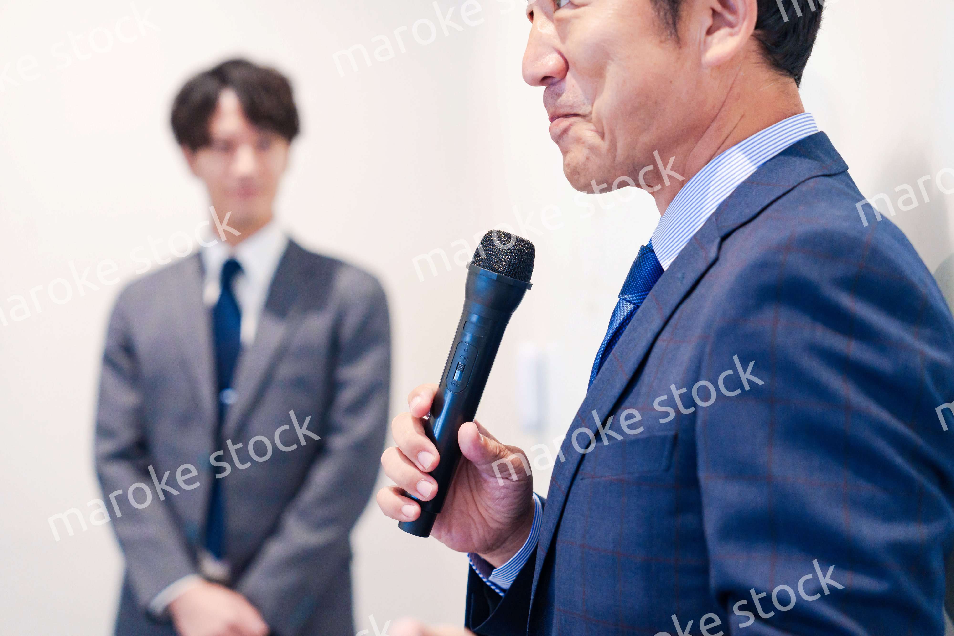 マイクを使って演説をする中年の男性