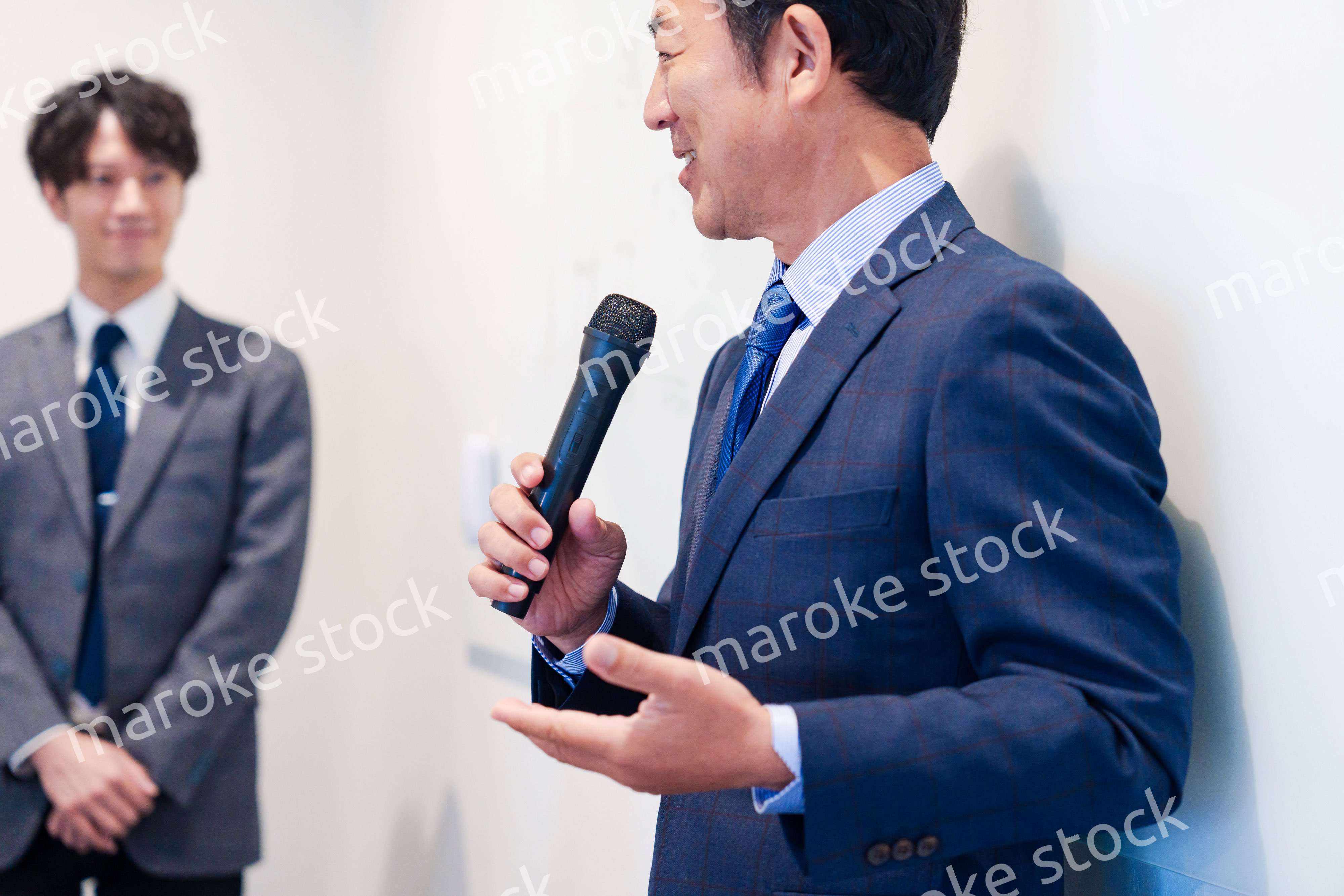 マイクを使って演説をする中年の男性
