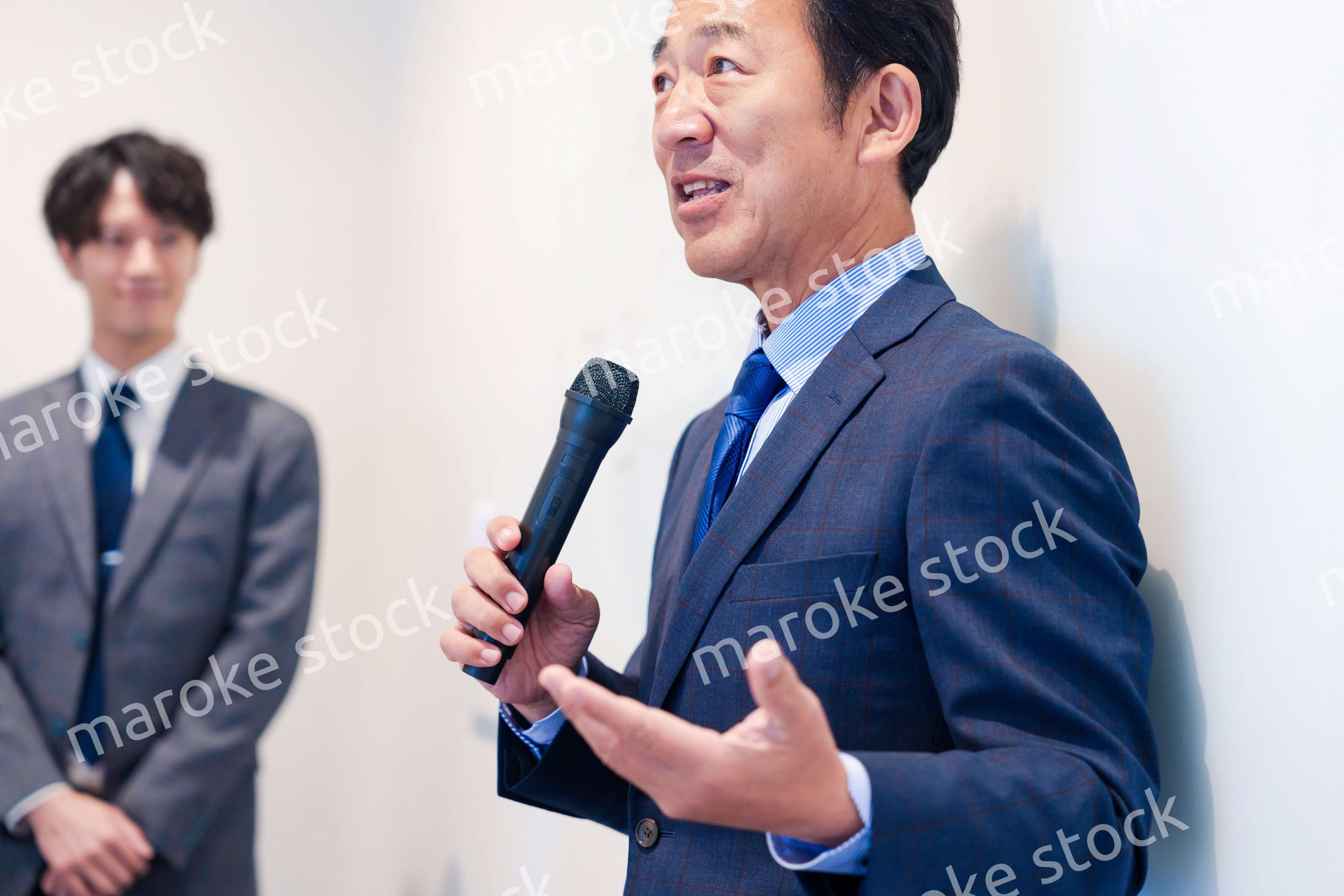 マイクを使って演説をする中年の男性
