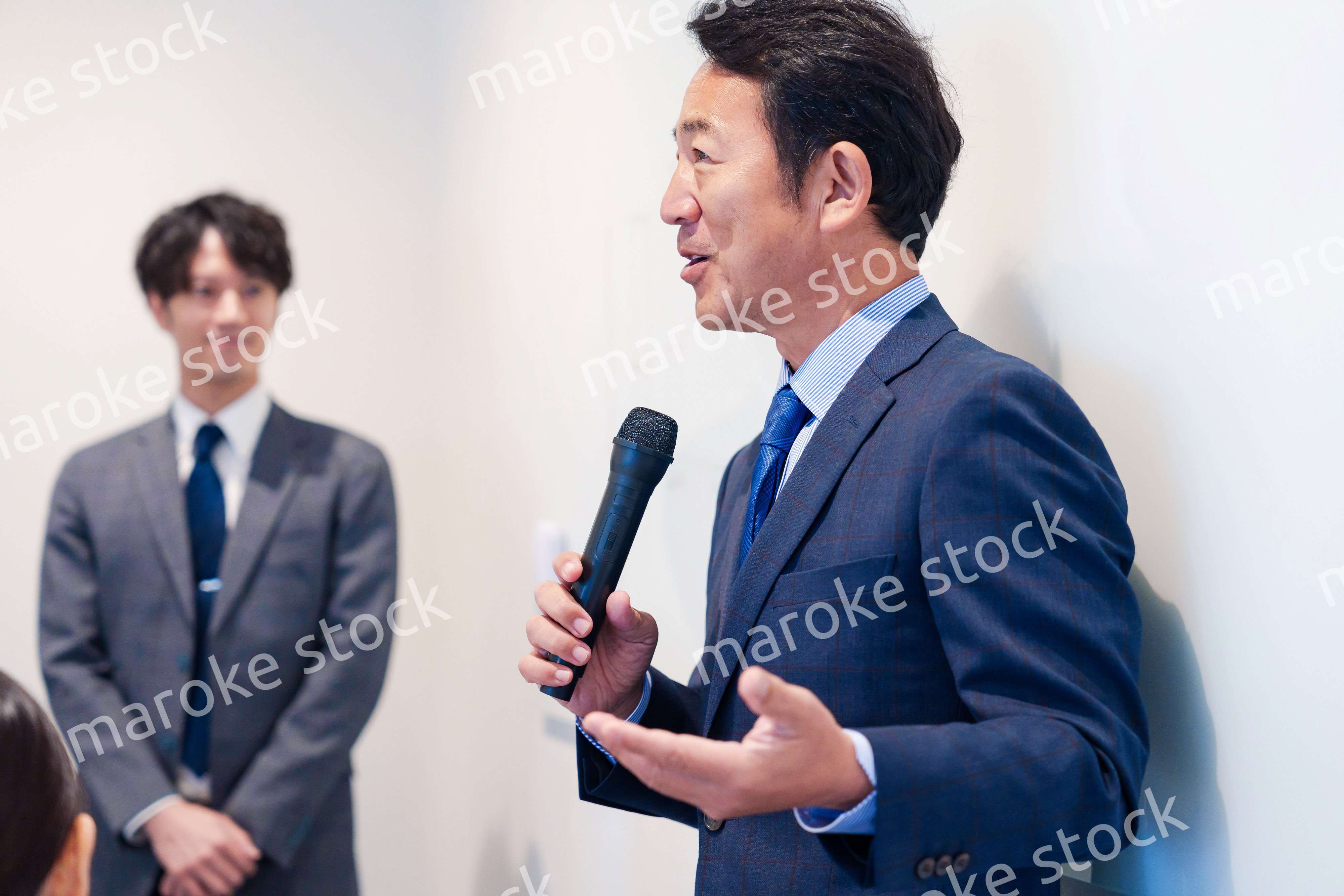 マイクを使って演説をする中年の男性