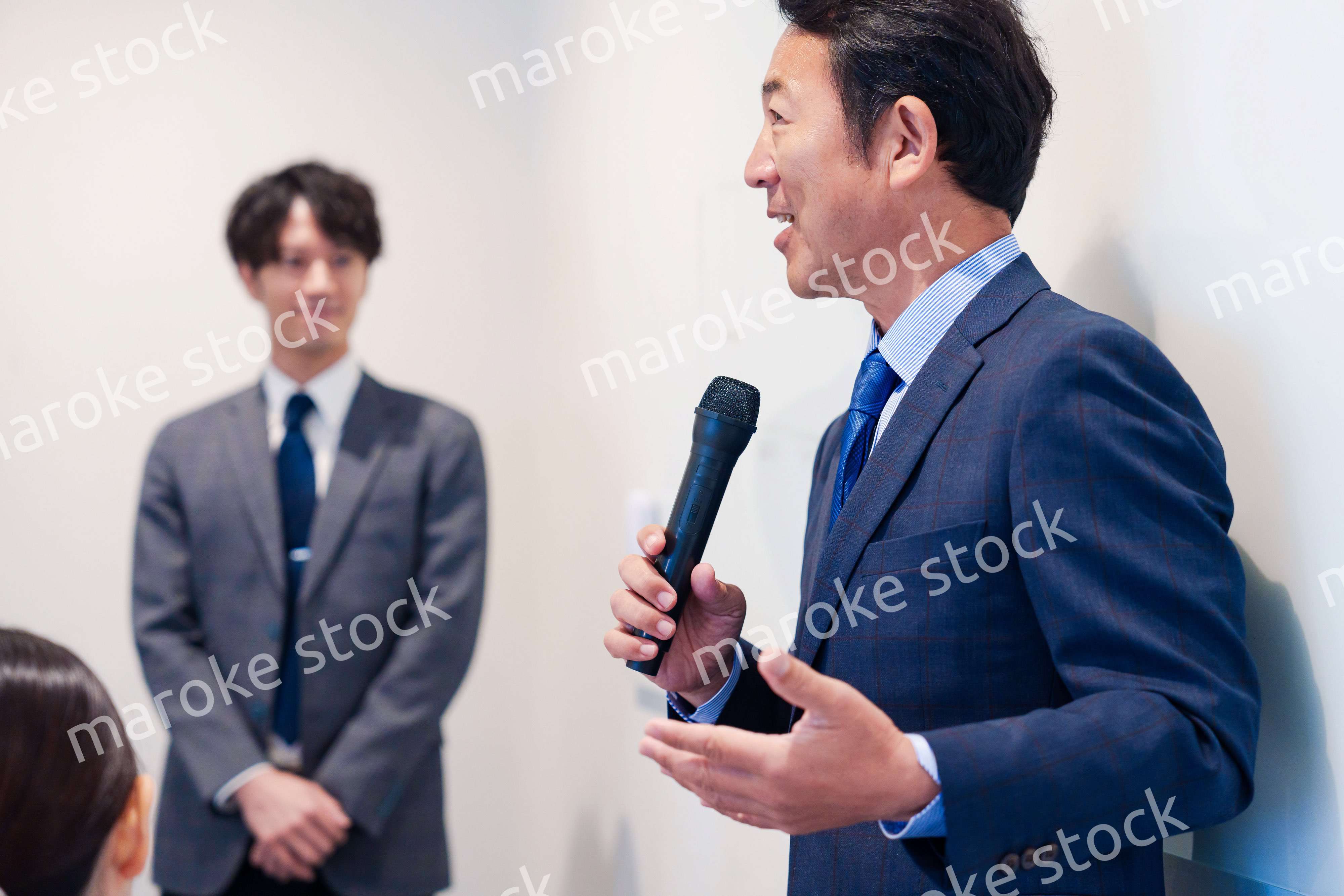 マイクを使って演説をする中年の男性