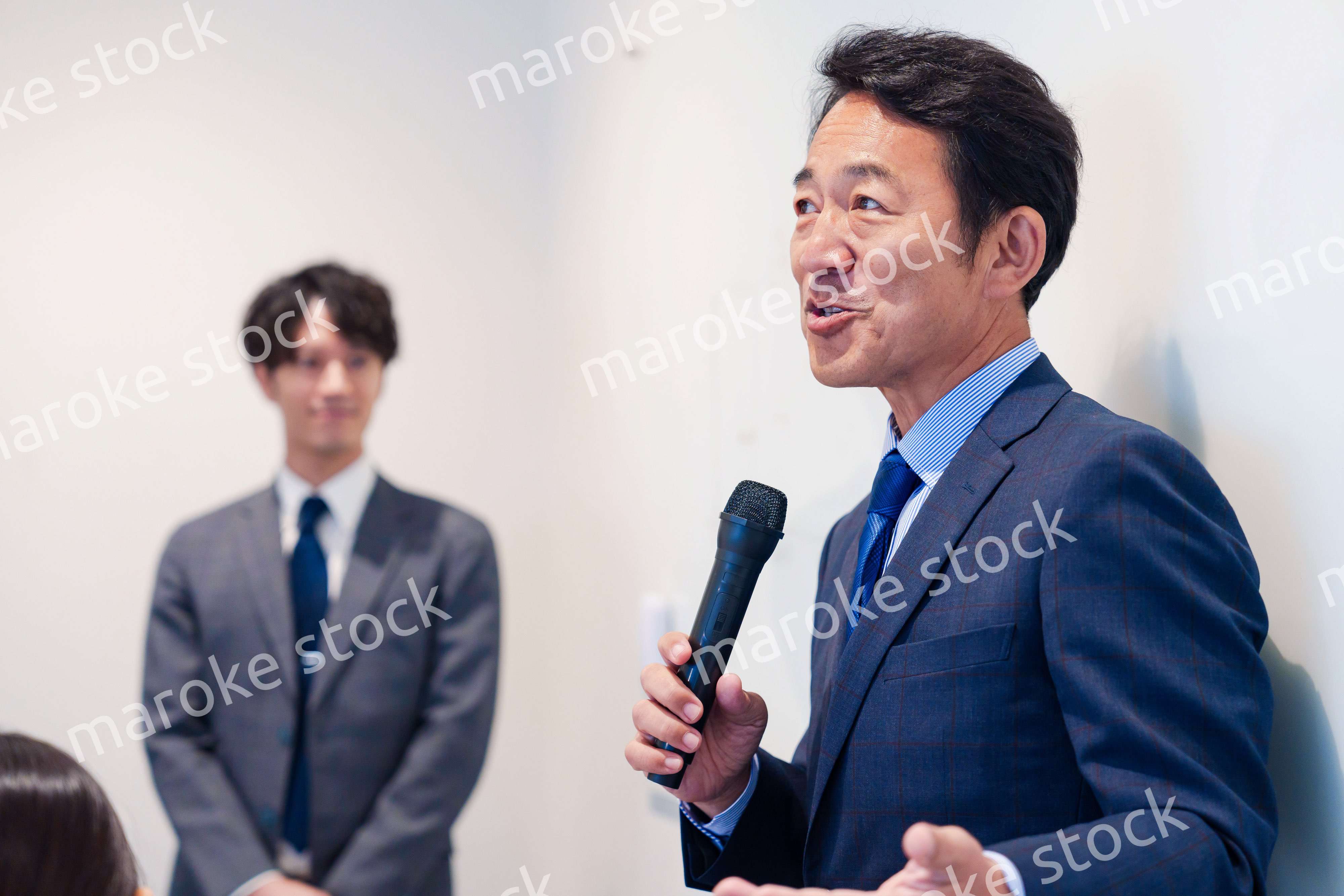 マイクを使って演説をする中年の男性