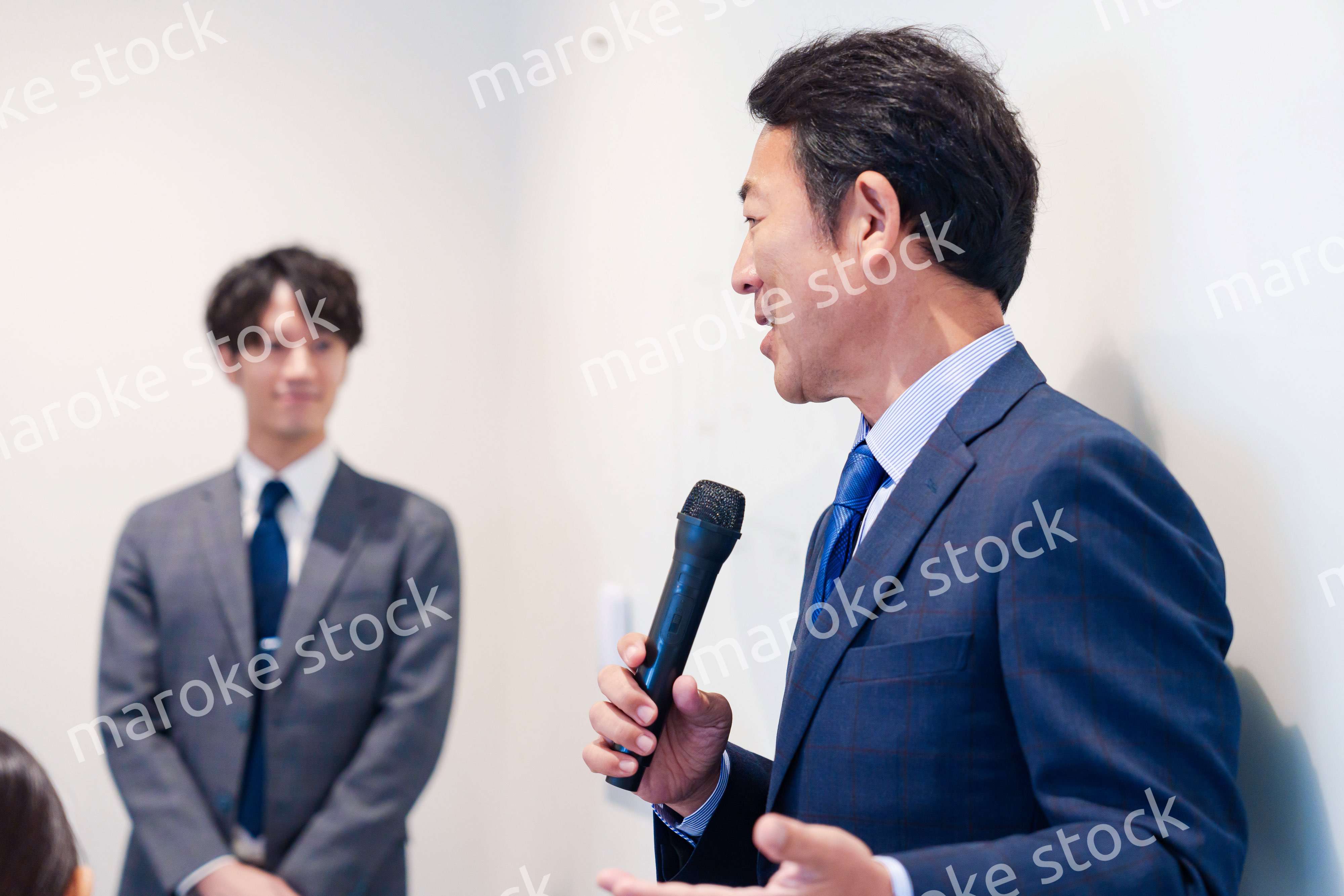 マイクを使って演説をする中年の男性