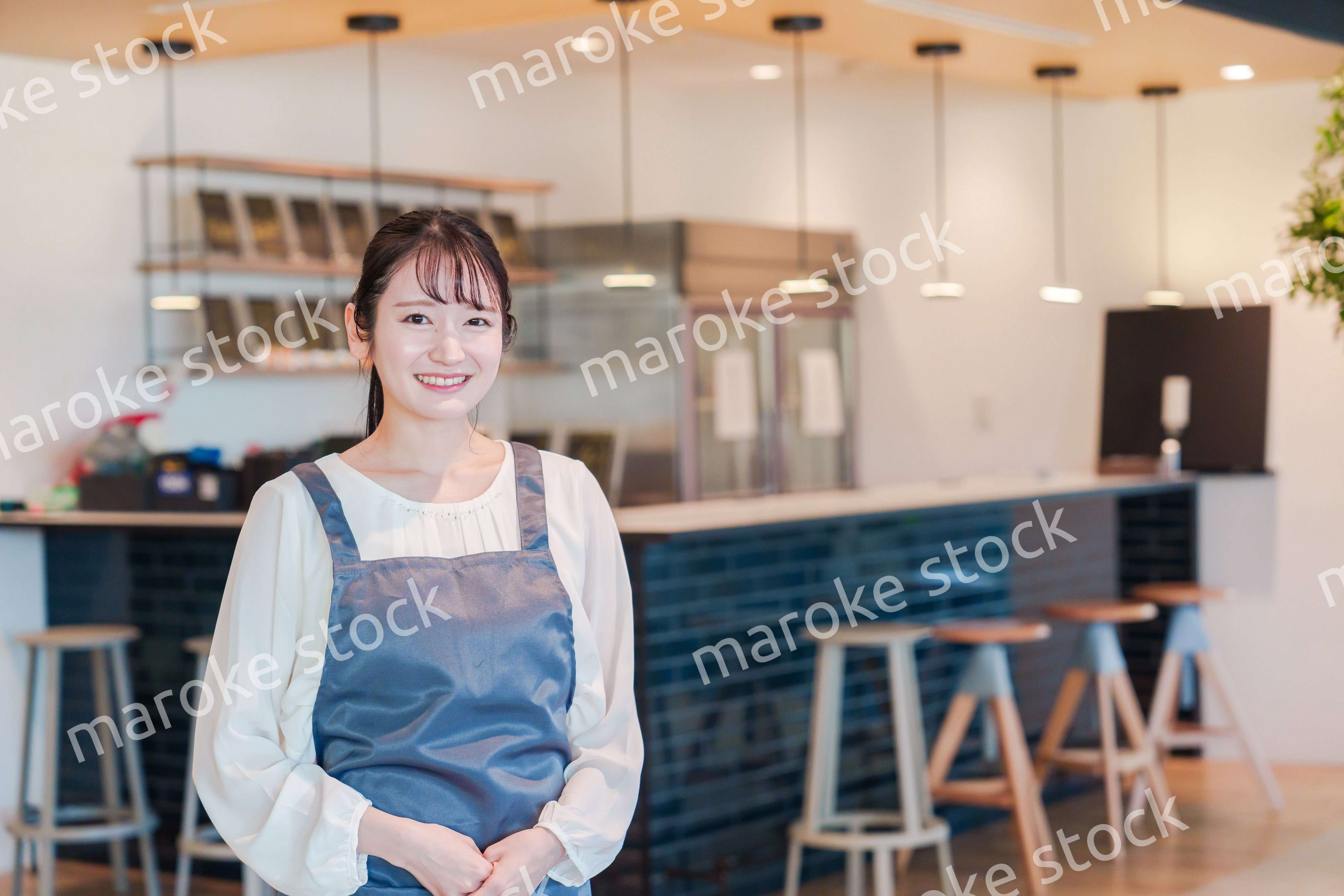 笑顔で働くカフェスタッフの女性