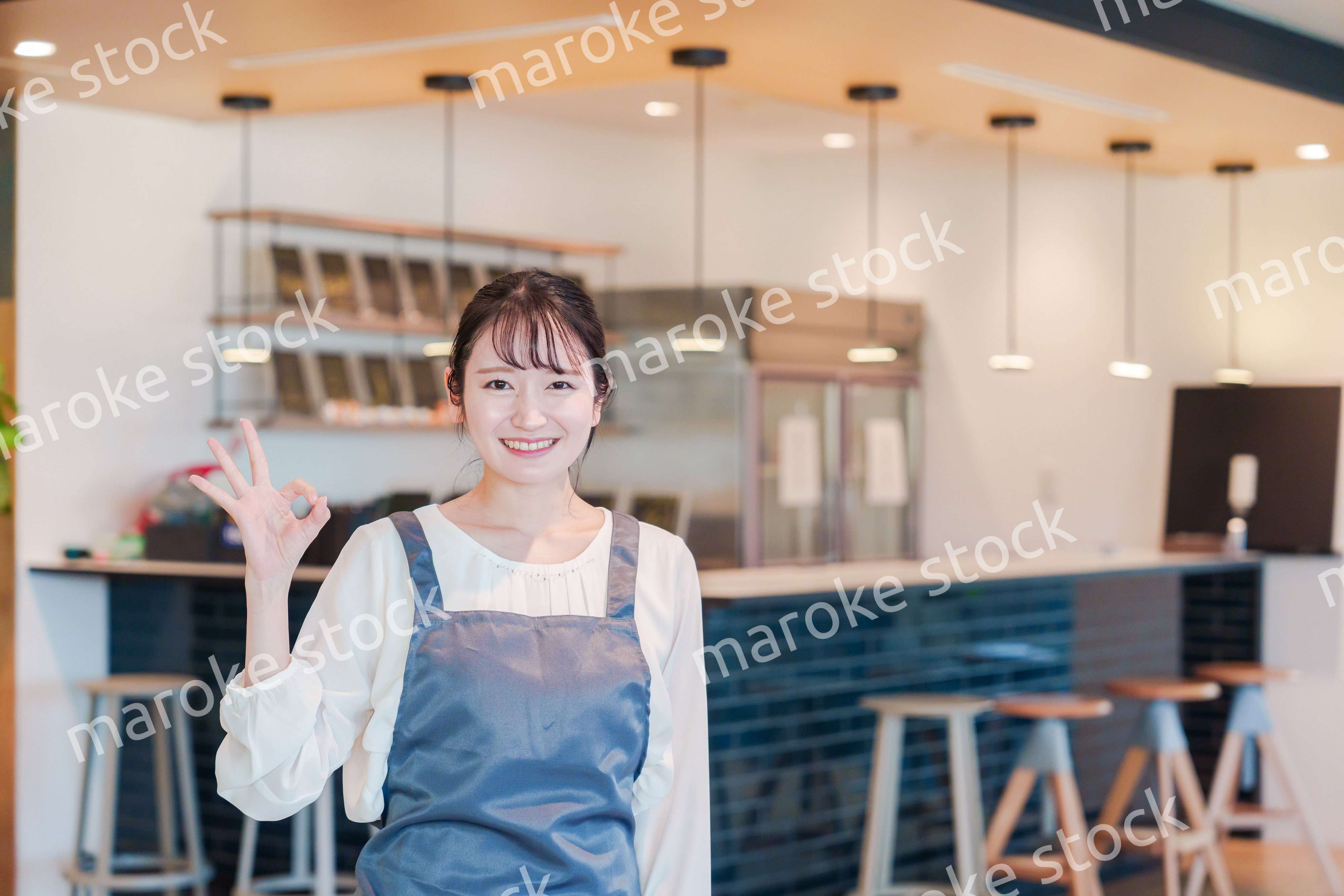 笑顔で働くカフェスタッフの女性