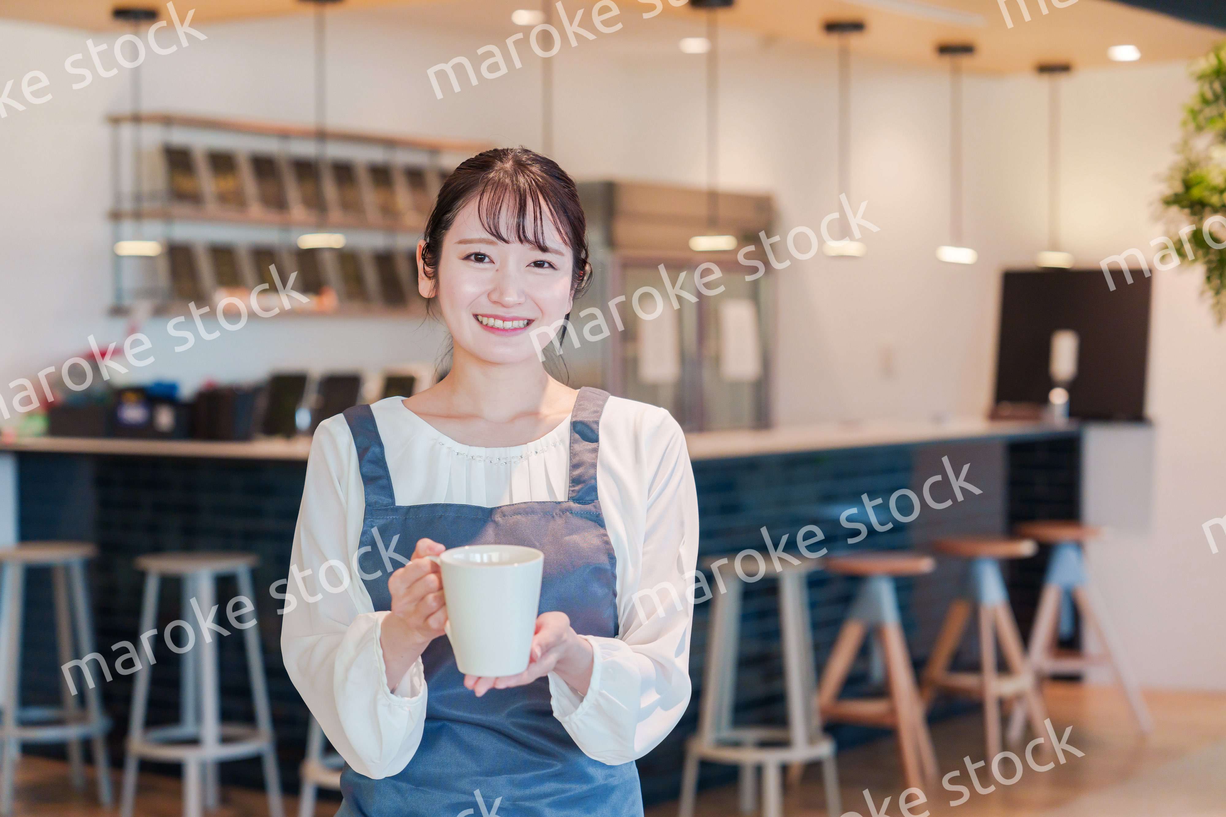笑顔で働くカフェスタッフの女性