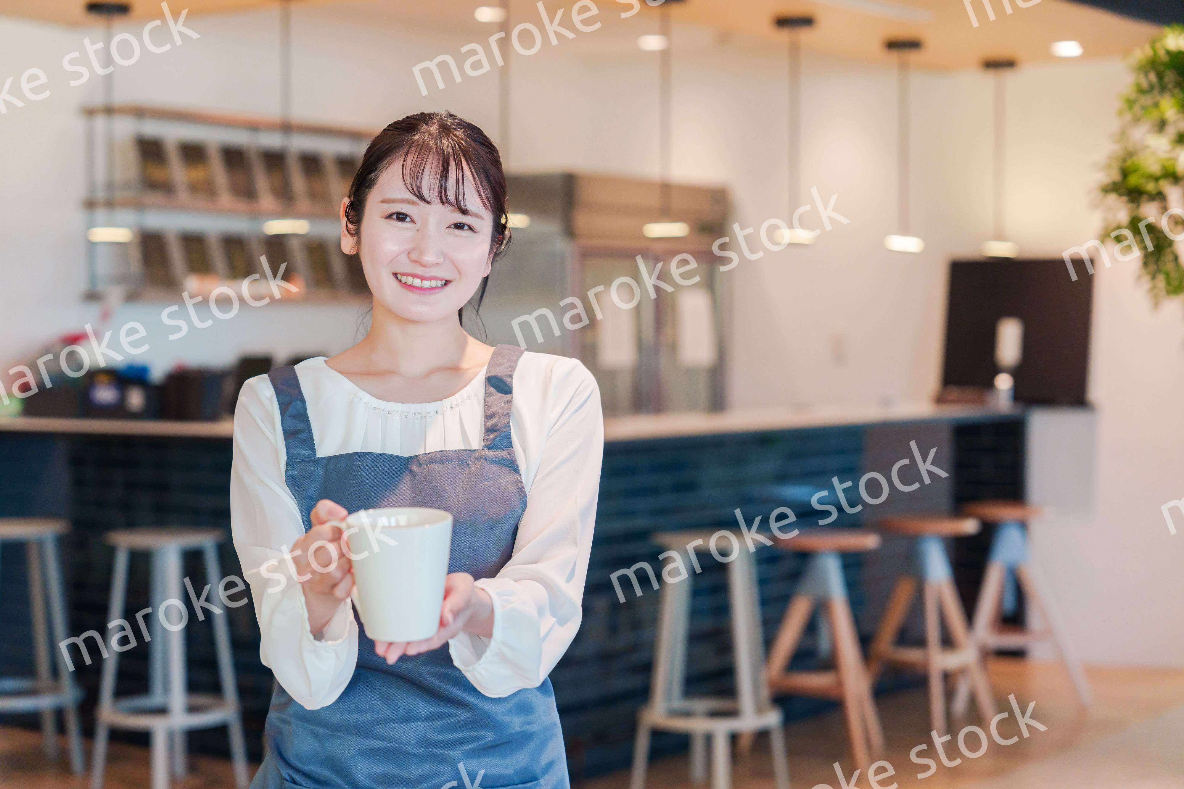笑顔で働くカフェスタッフの女性