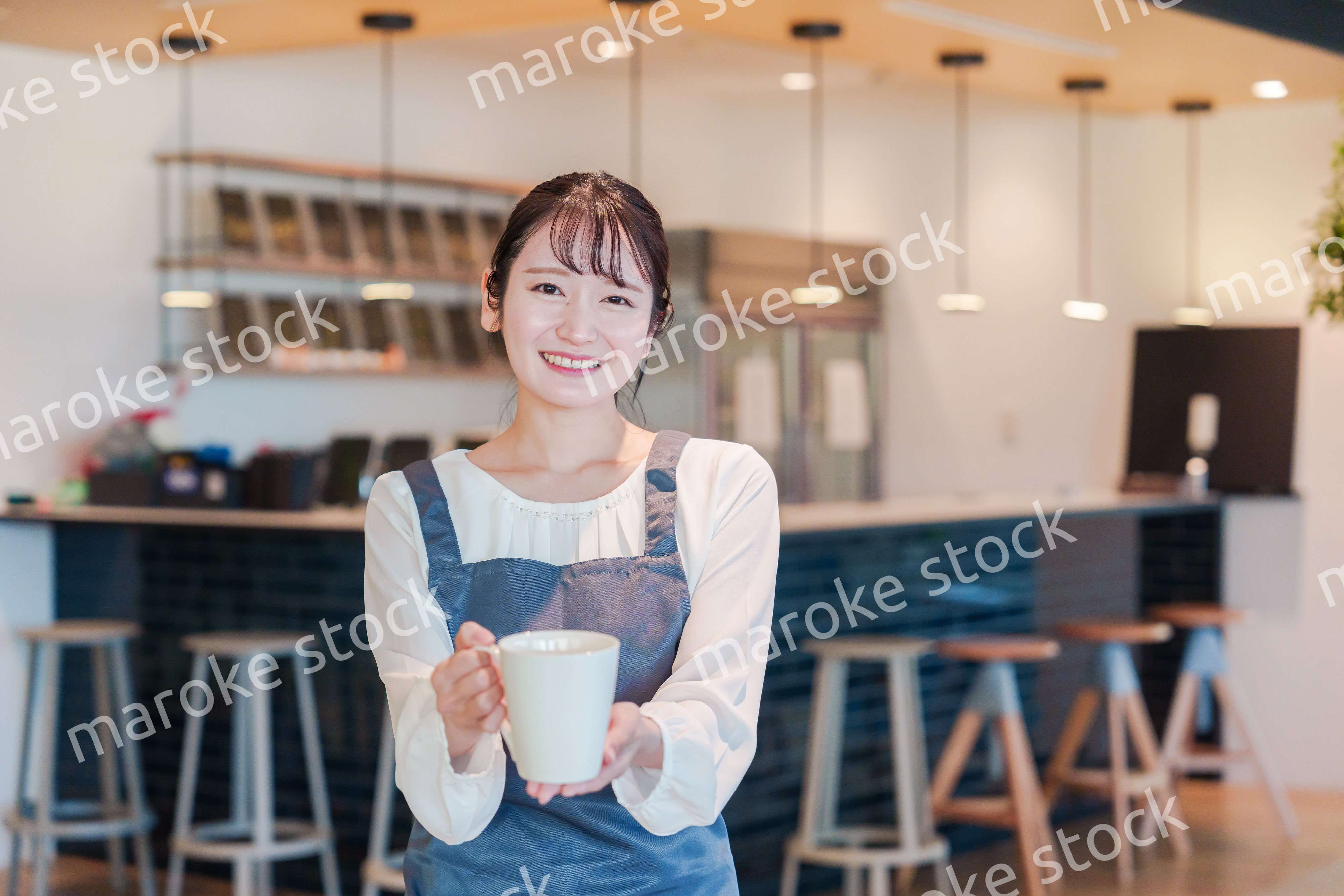 笑顔で働くカフェスタッフの女性