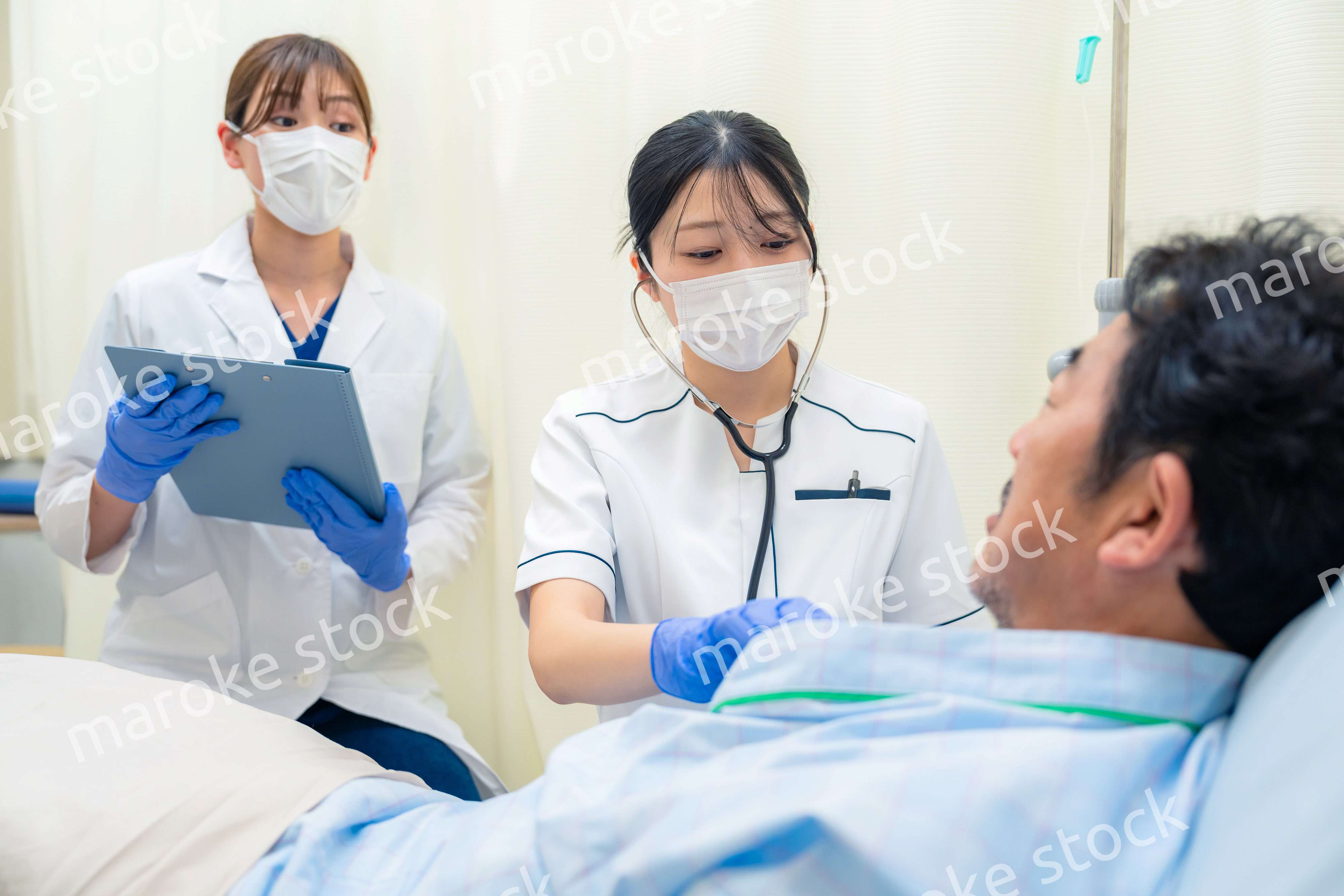 病棟で入院患者のバイタルチェックをする看護師の女性