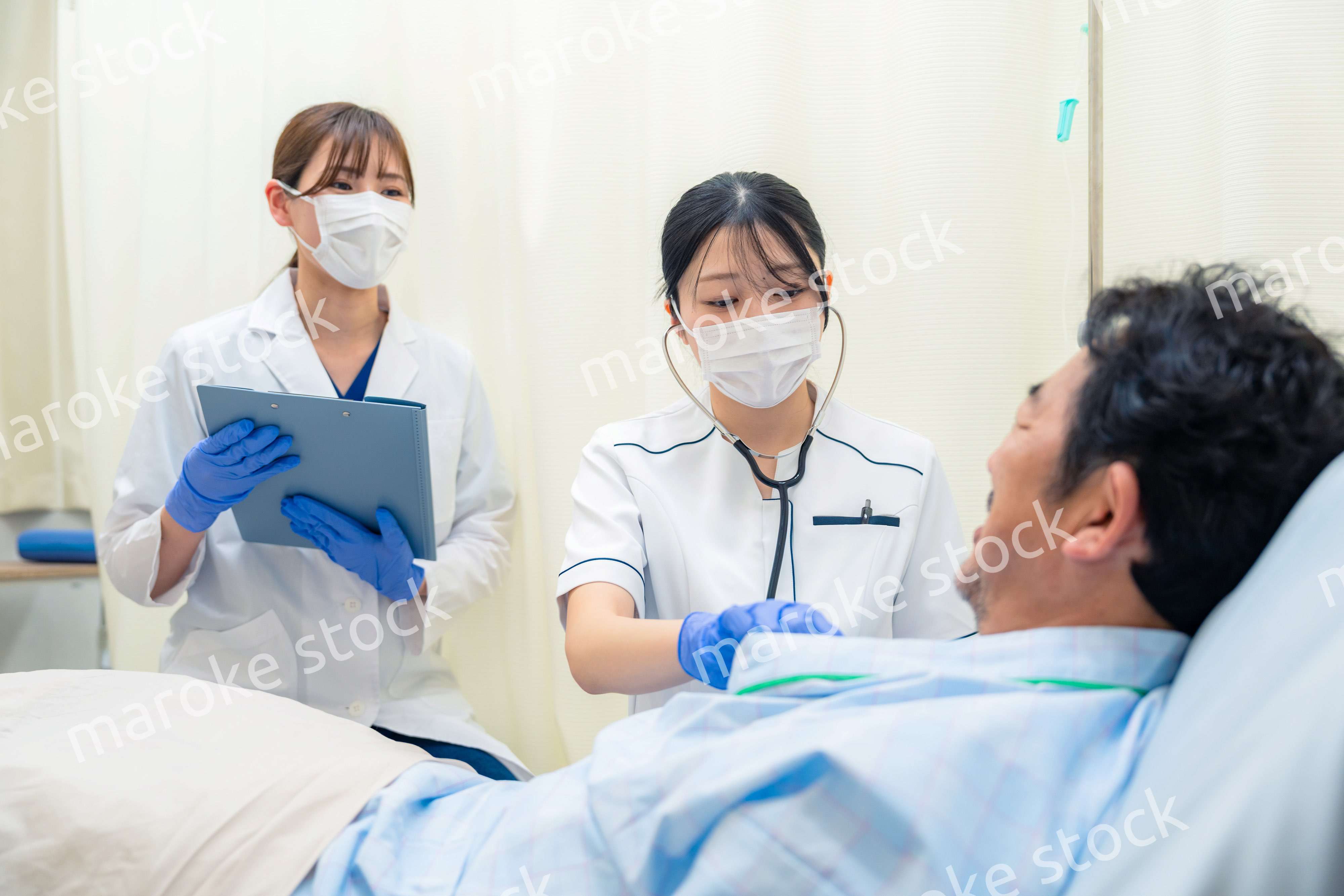 病棟で入院患者のバイタルチェックをする看護師の女性