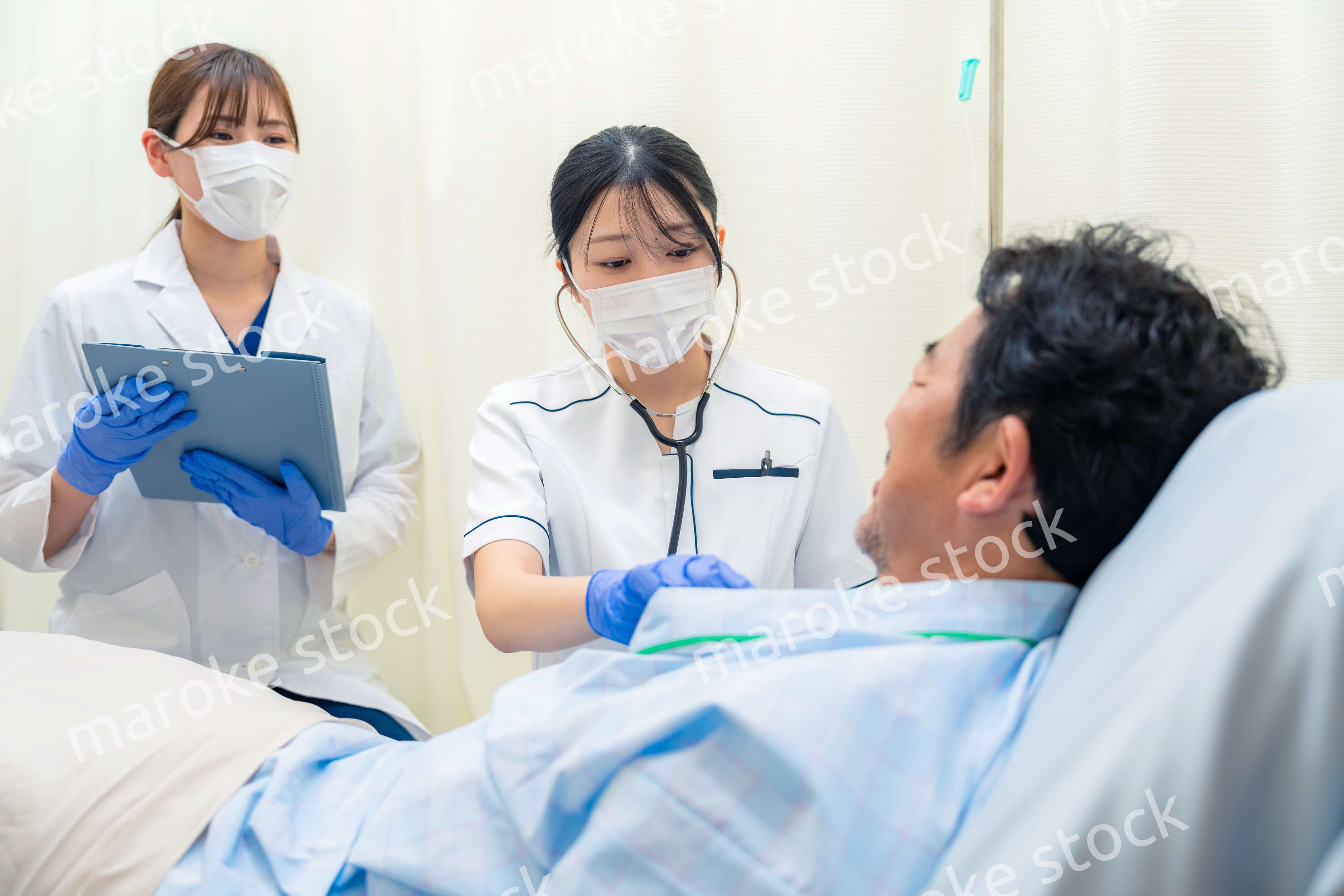 病棟で入院患者のバイタルチェックをする看護師の女性