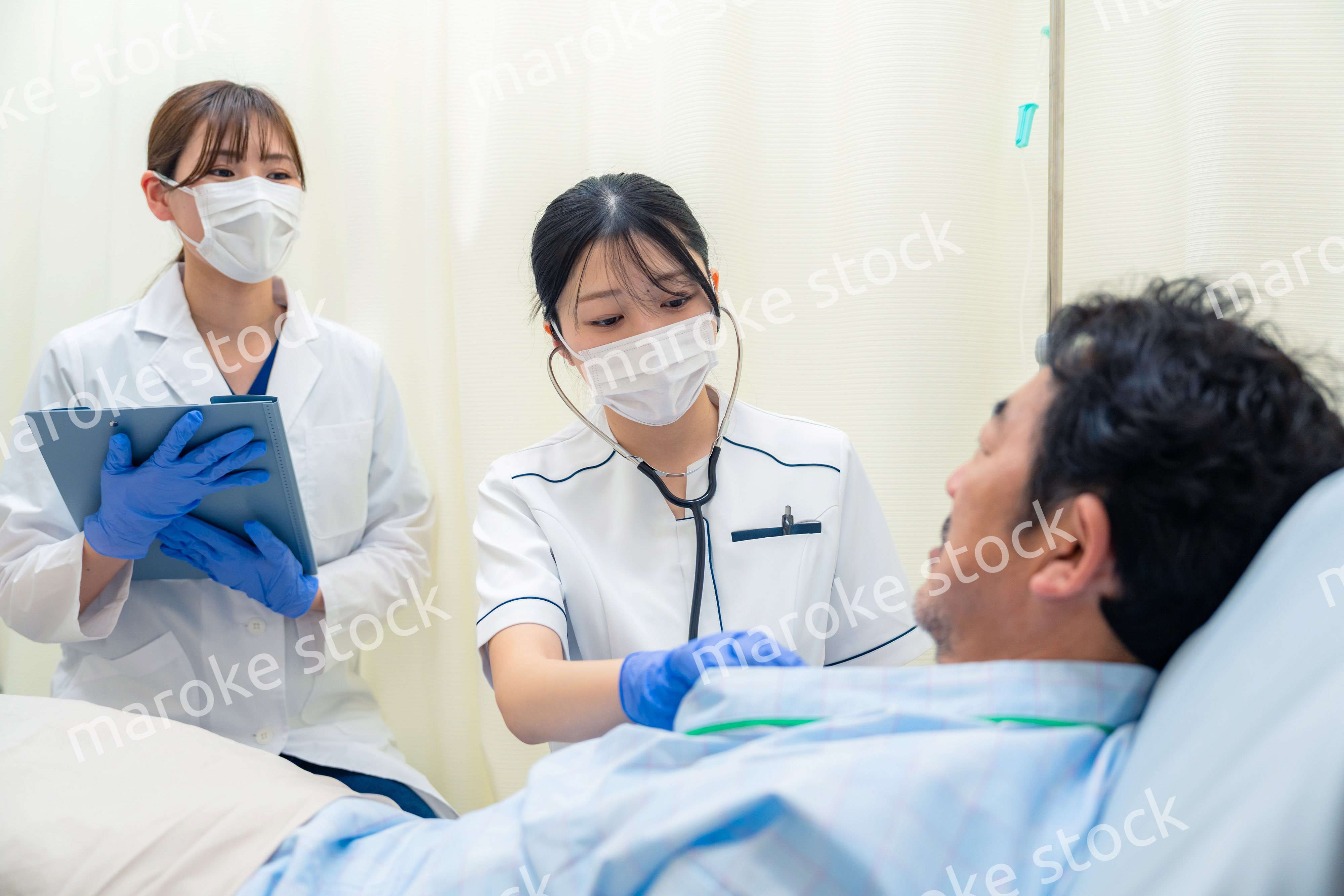 病棟で入院患者のバイタルチェックをする看護師の女性