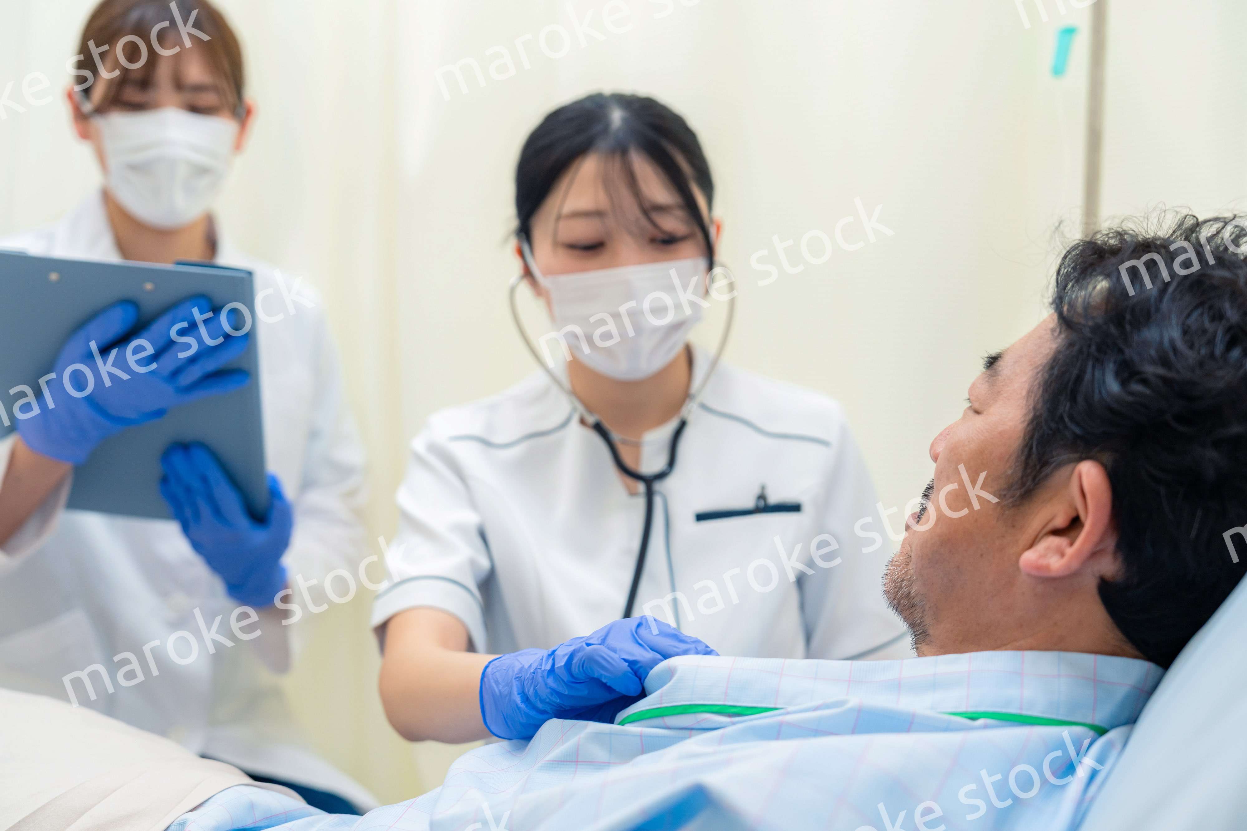 病棟で入院患者のバイタルチェックをする看護師の女性