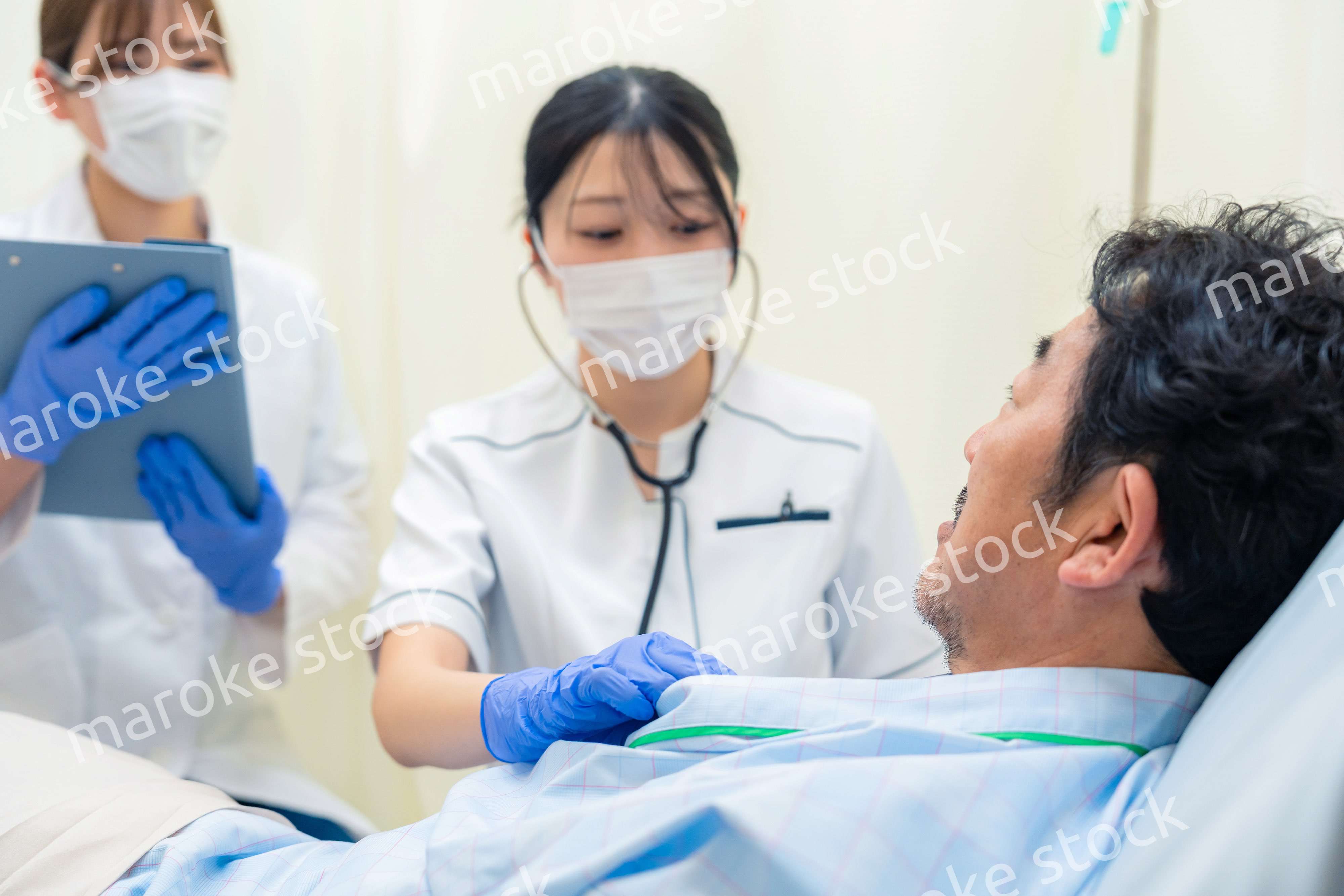 病棟で入院患者のバイタルチェックをする看護師の女性