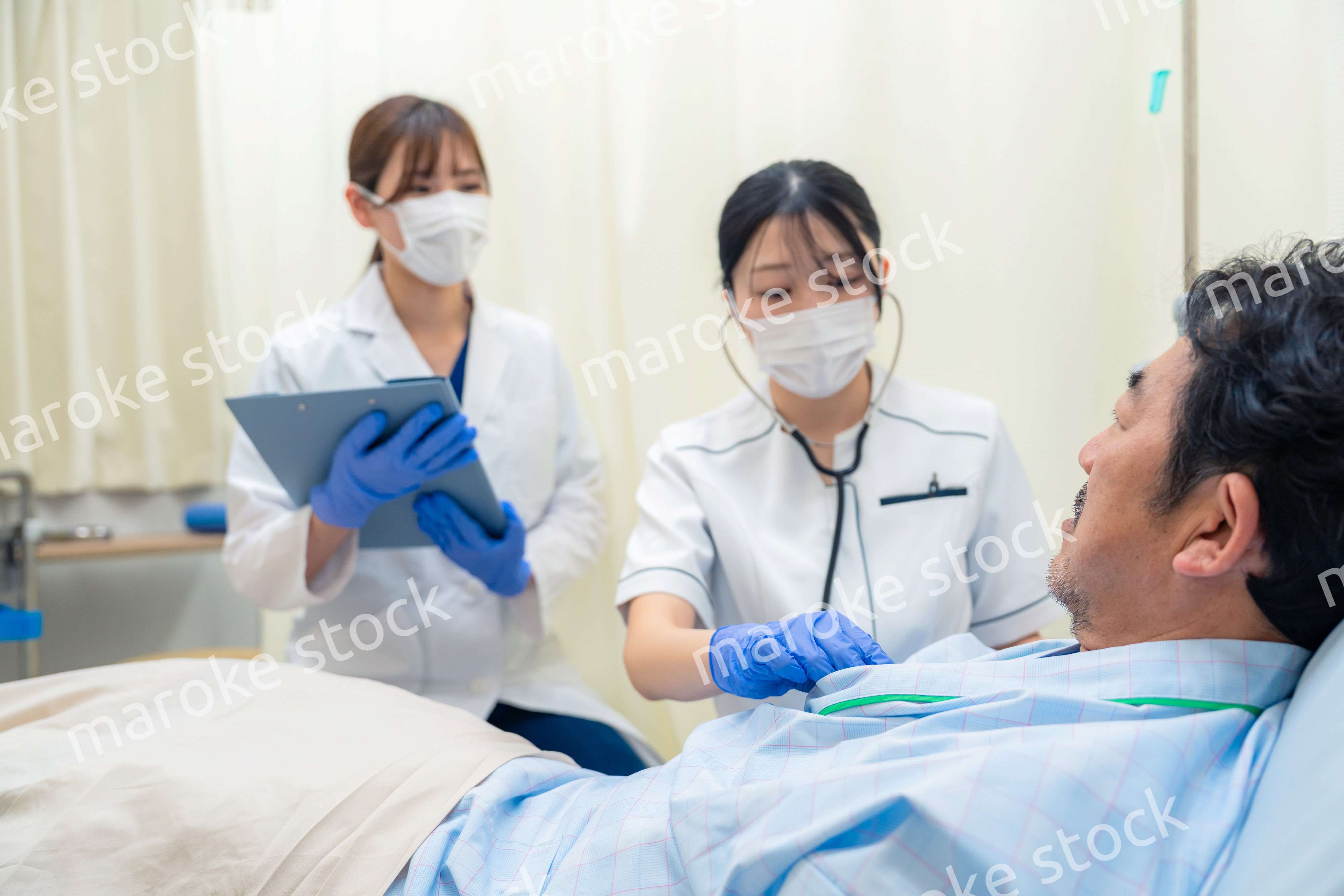 病棟で入院患者のバイタルチェックをする看護師の女性