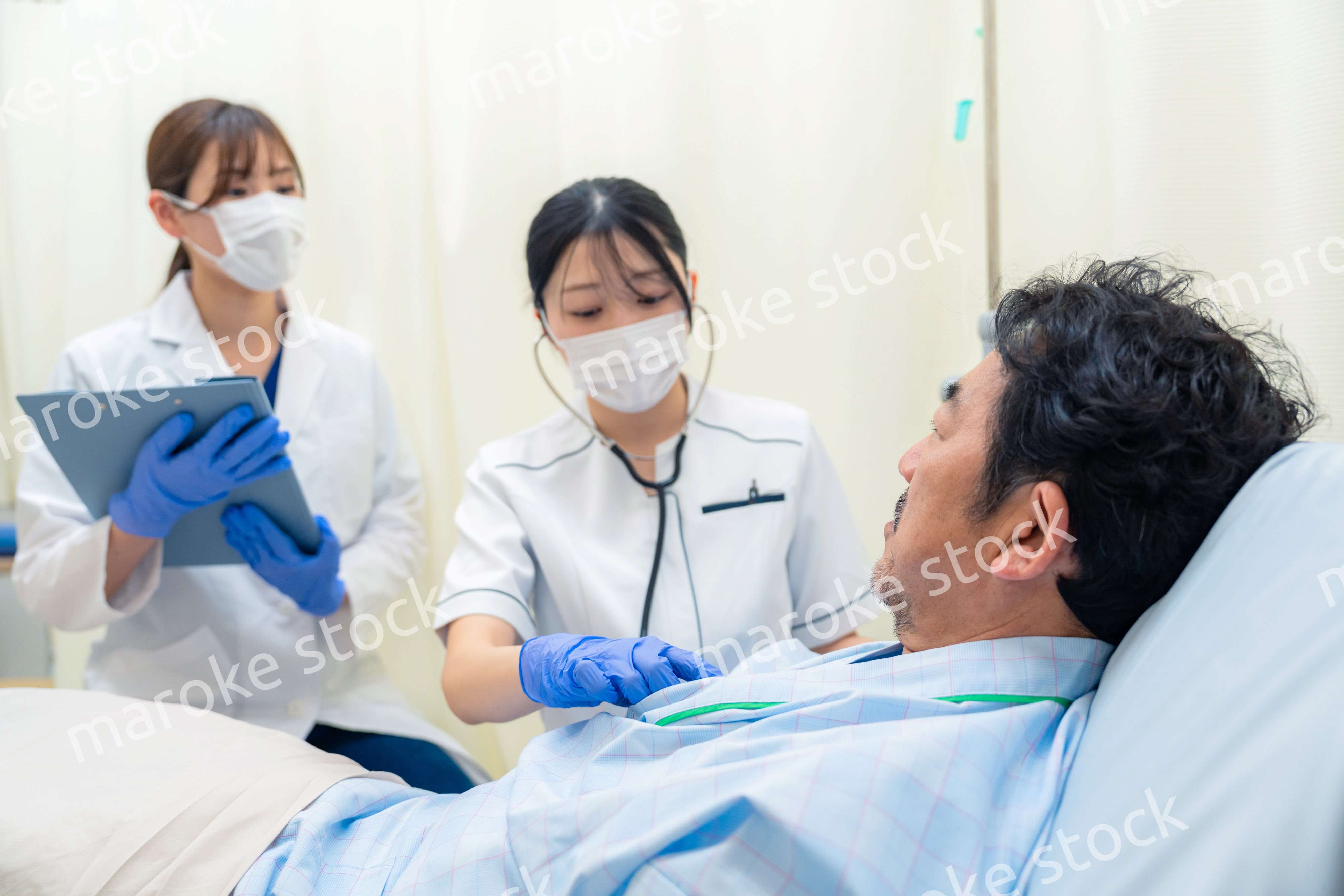 病棟で入院患者のバイタルチェックをする看護師の女性