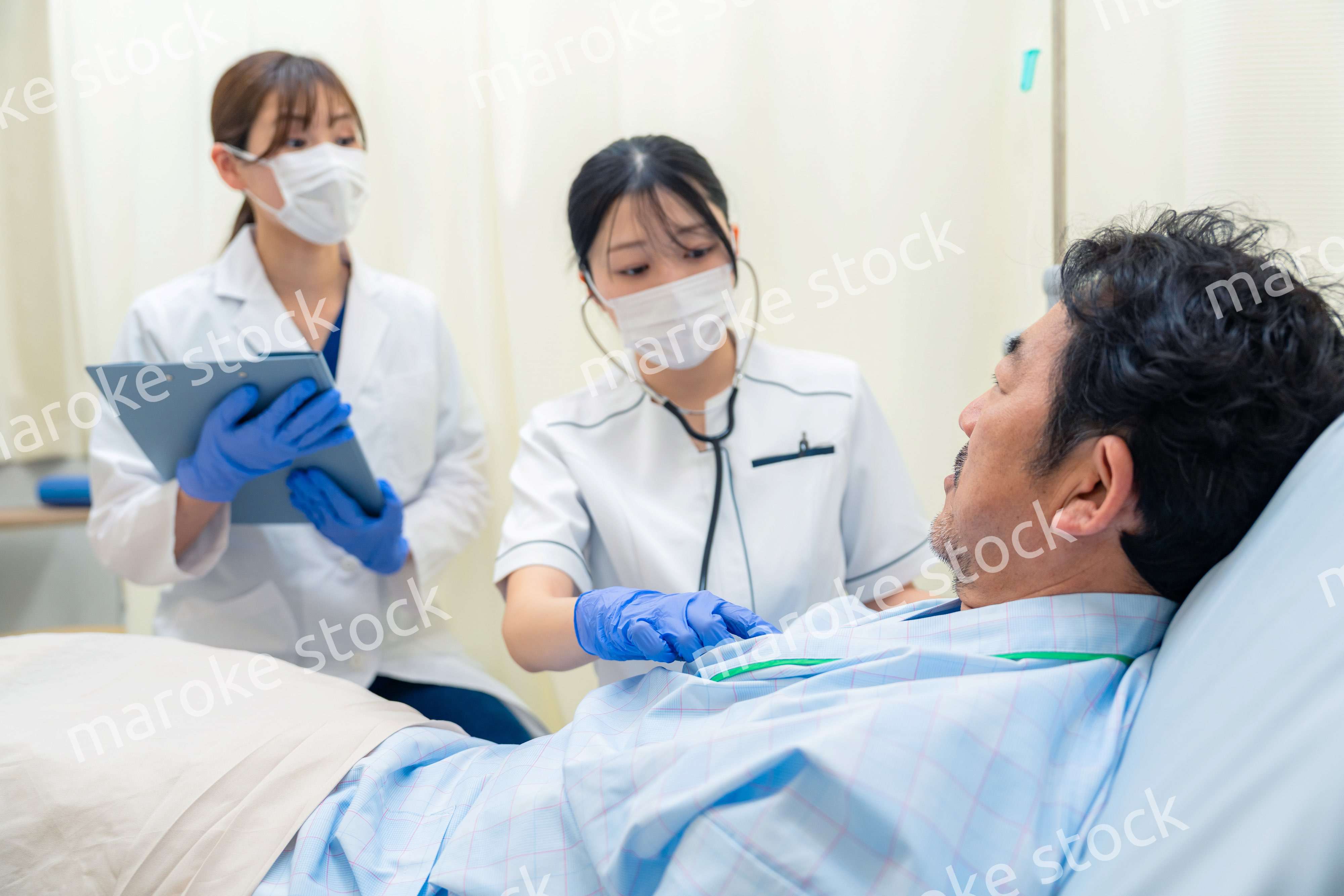 病棟で入院患者のバイタルチェックをする看護師の女性