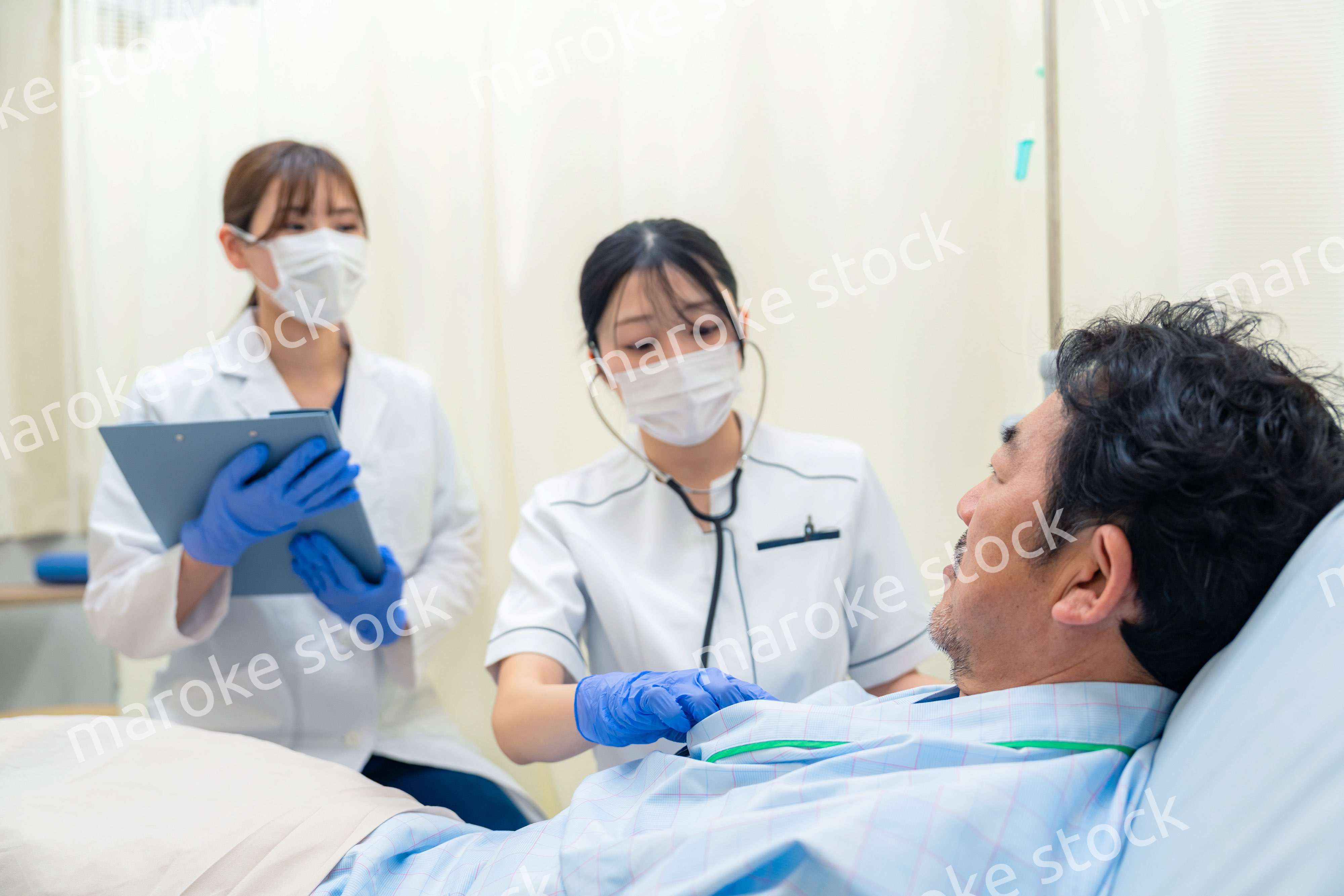 病棟で入院患者のバイタルチェックをする看護師の女性