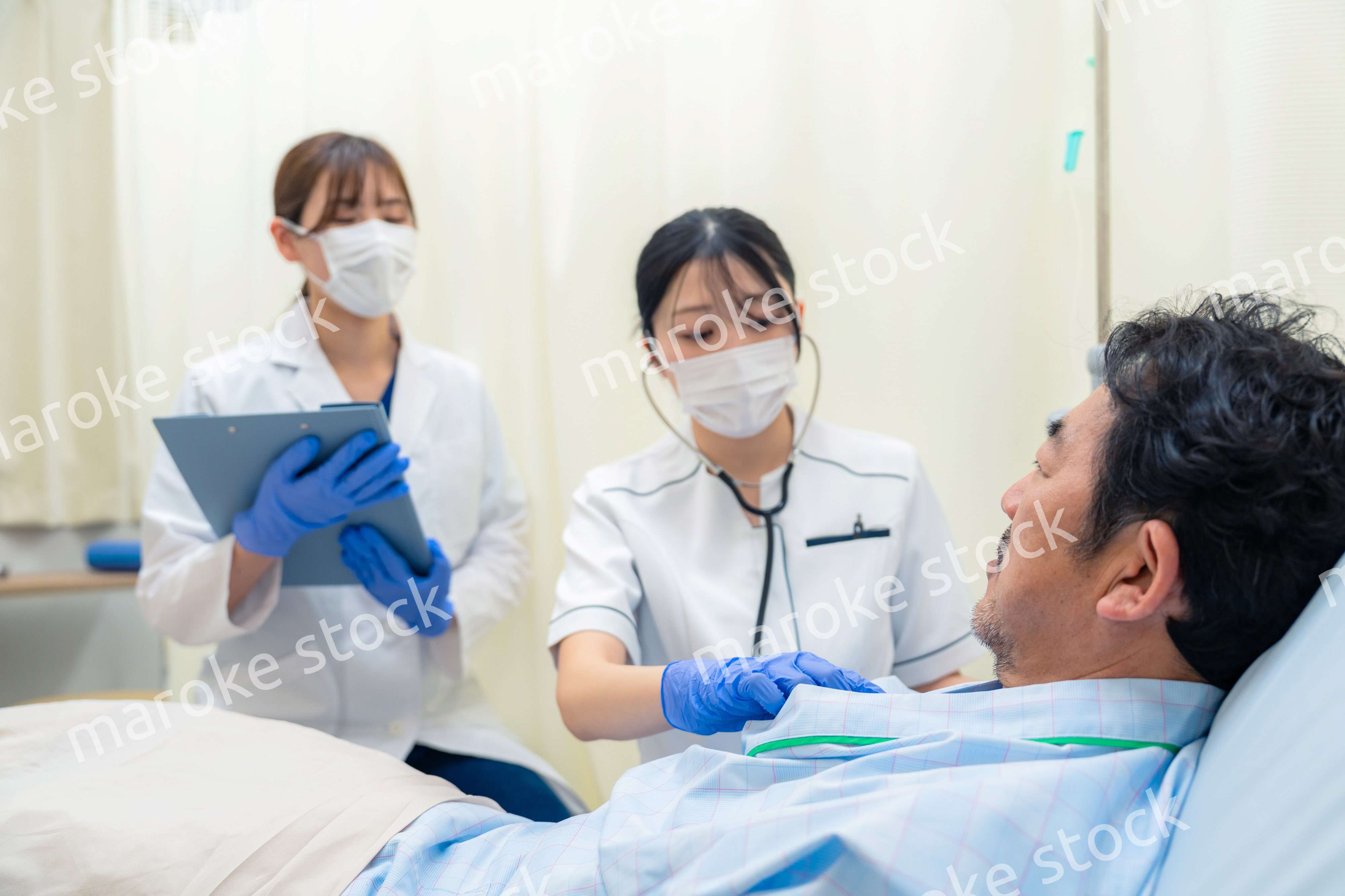 病棟で入院患者のバイタルチェックをする看護師の女性