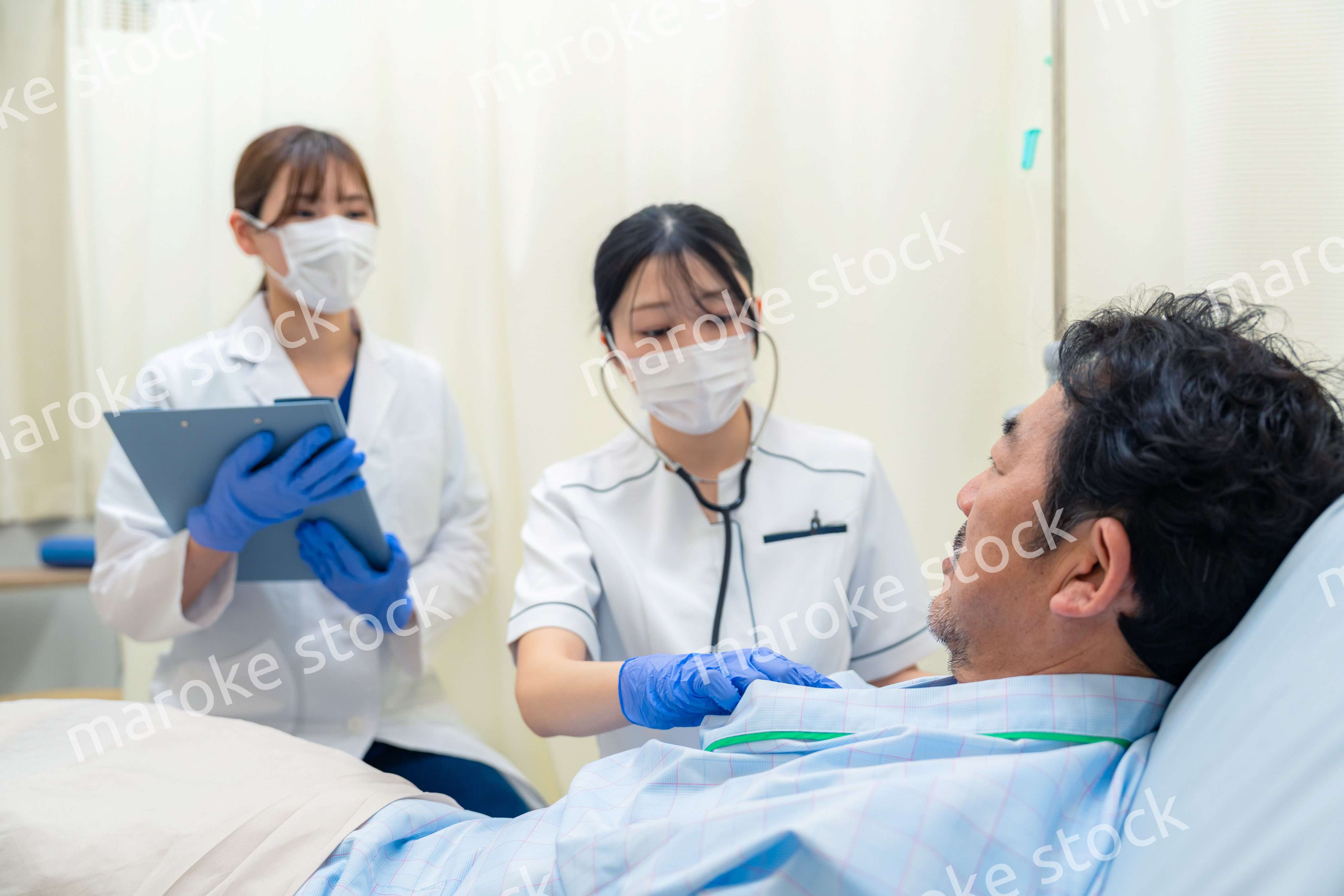 病棟で入院患者のバイタルチェックをする看護師の女性