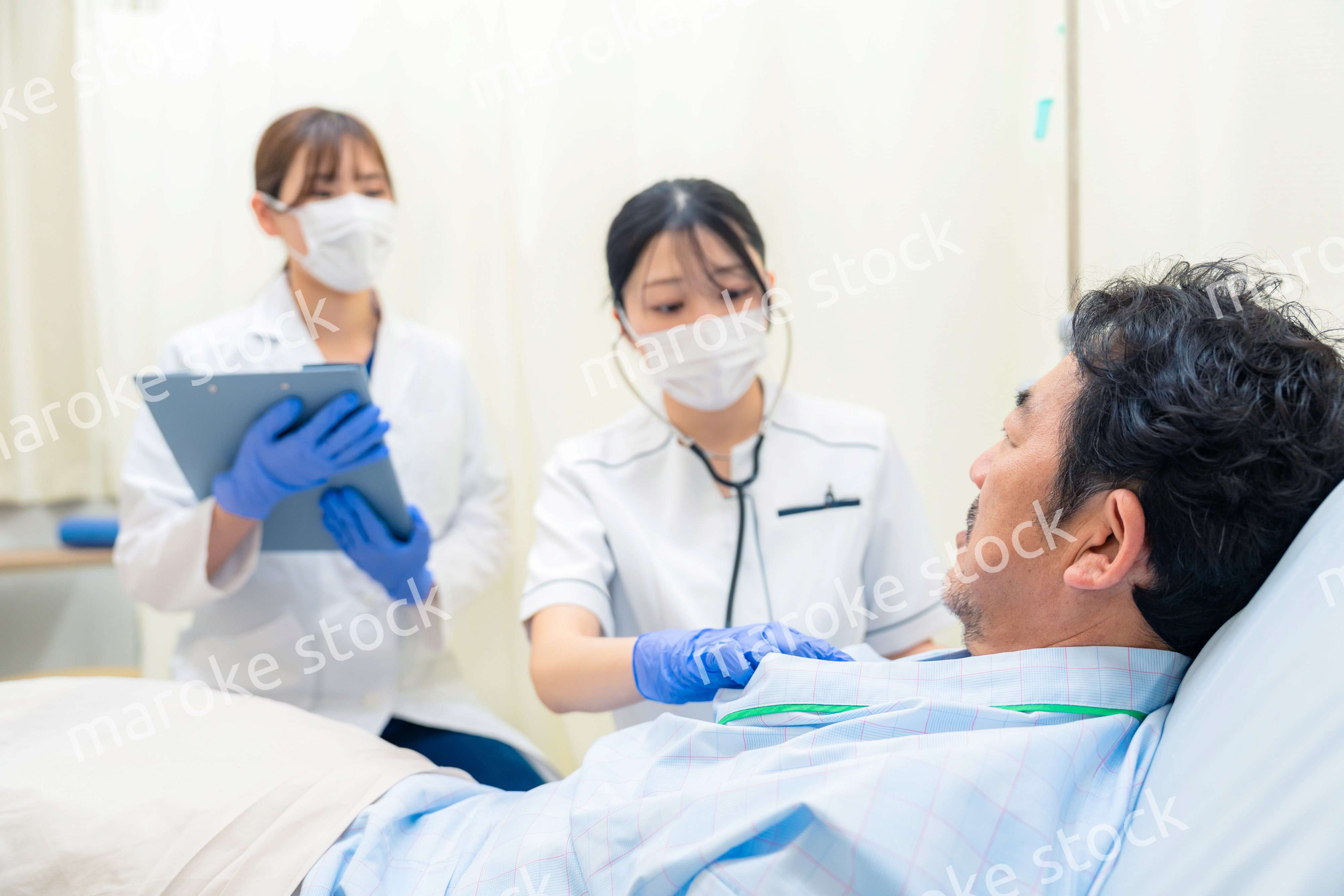 病棟で入院患者のバイタルチェックをする看護師の女性