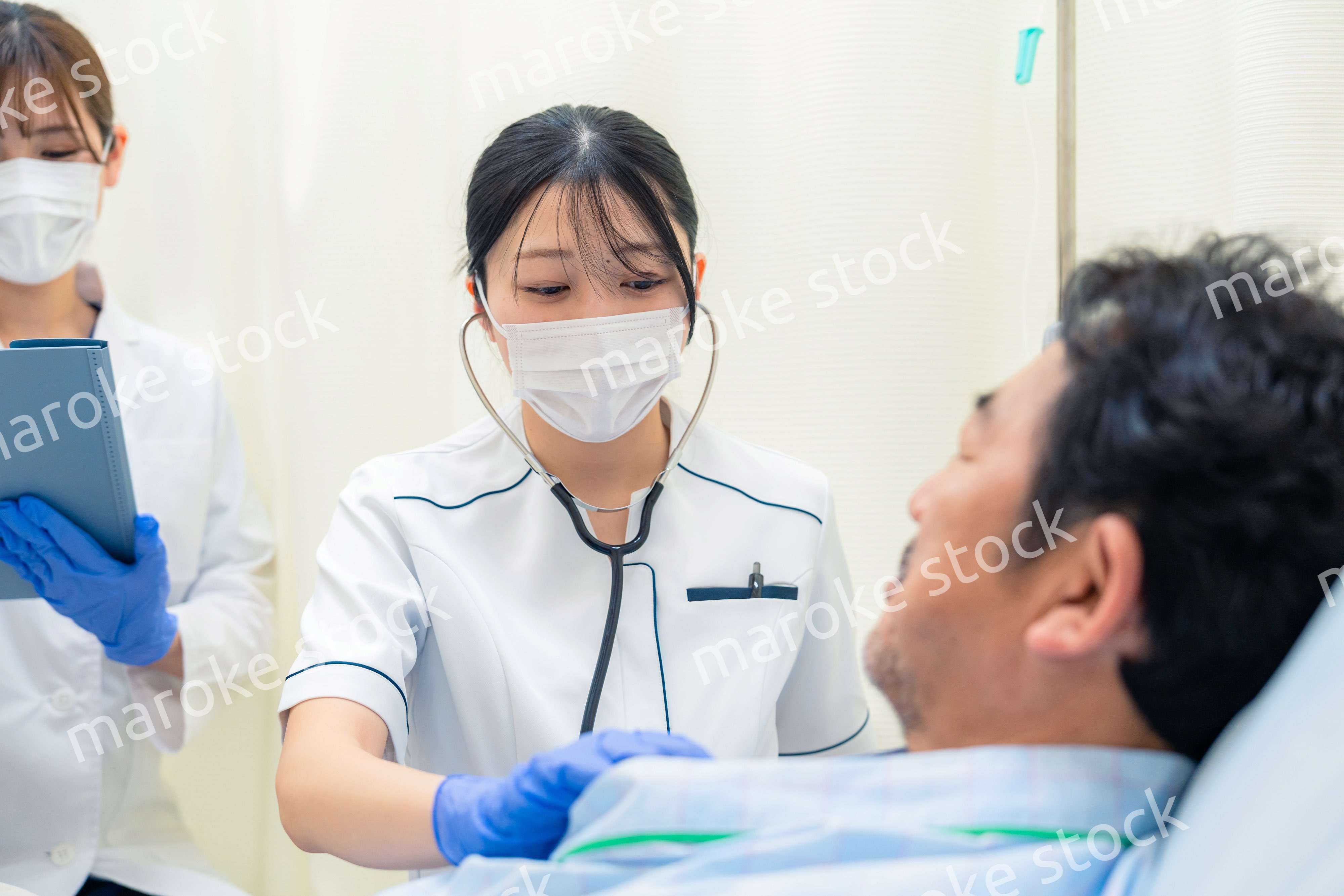 病棟で入院患者のバイタルチェックをする看護師の女性