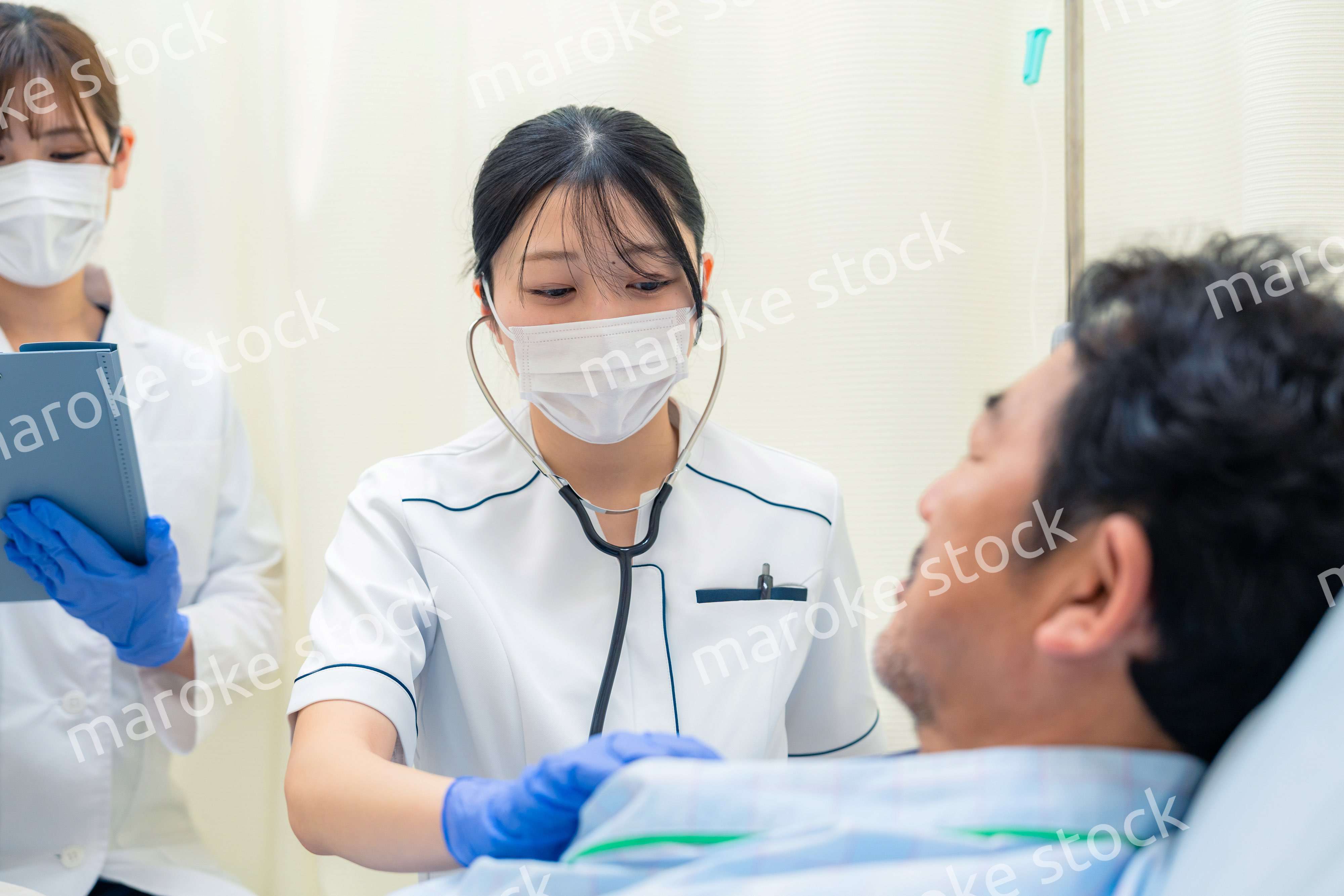 病棟で入院患者のバイタルチェックをする看護師の女性