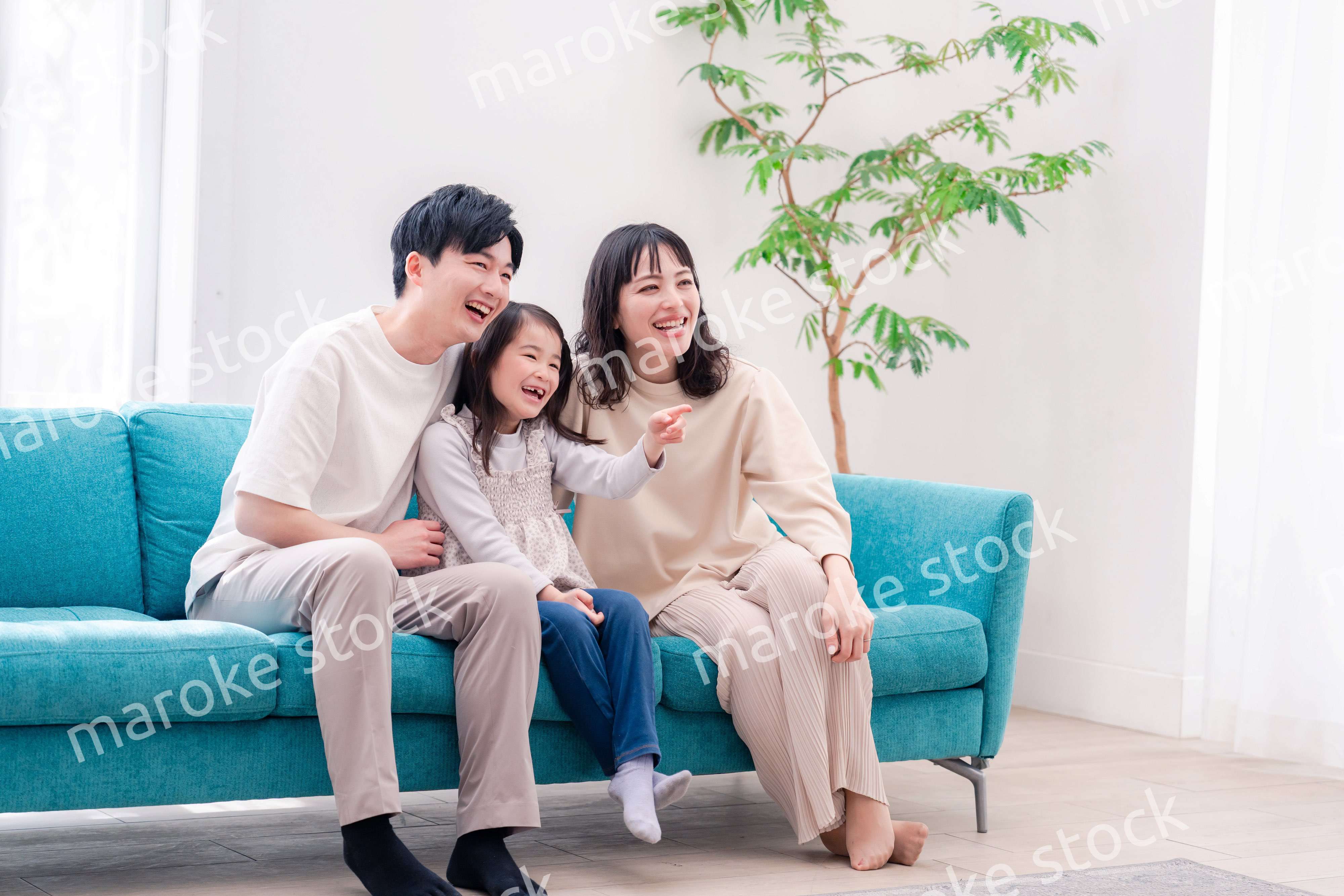 リビングでみんなでテレビを見るファミリー