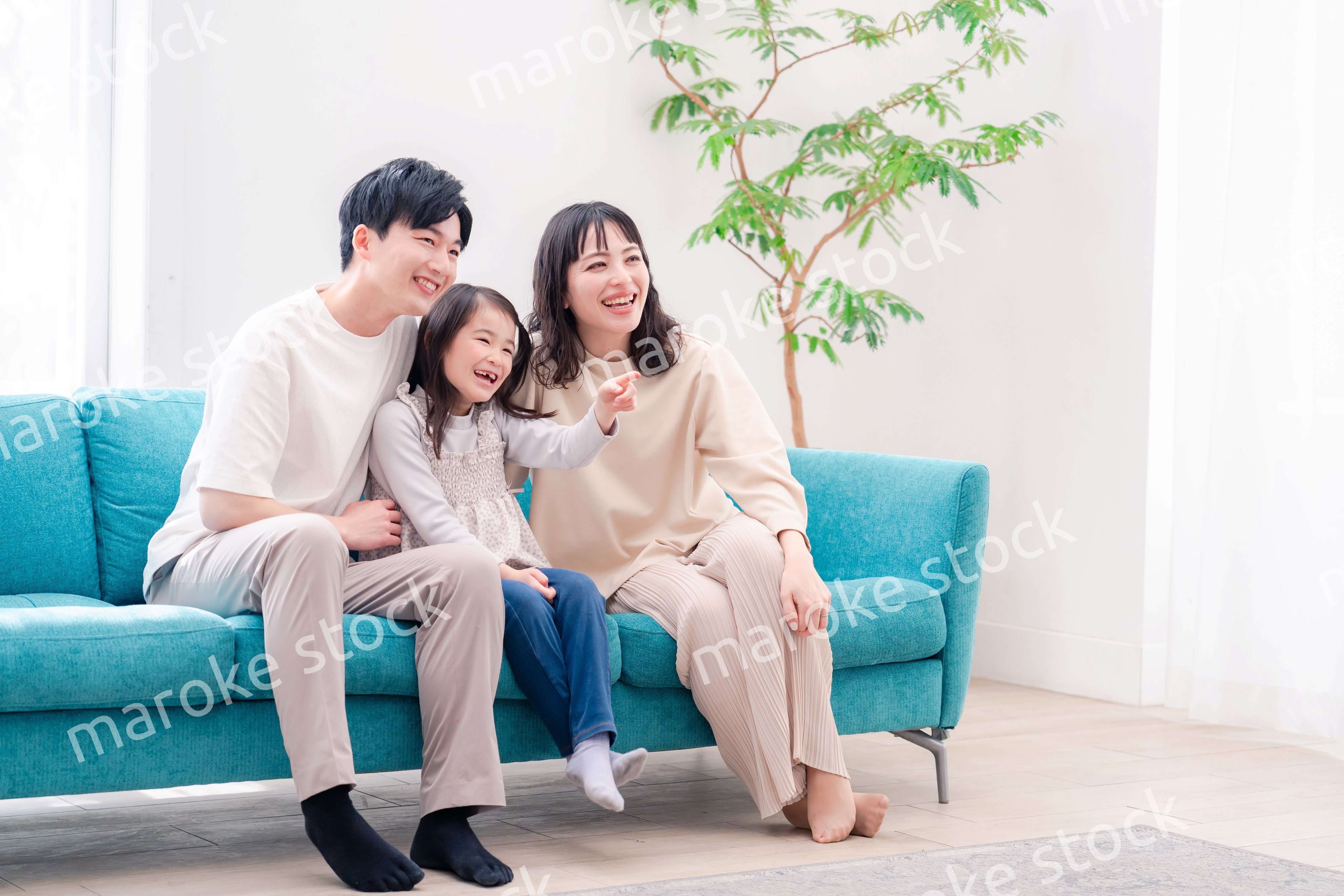 リビングでみんなでテレビを見るファミリー