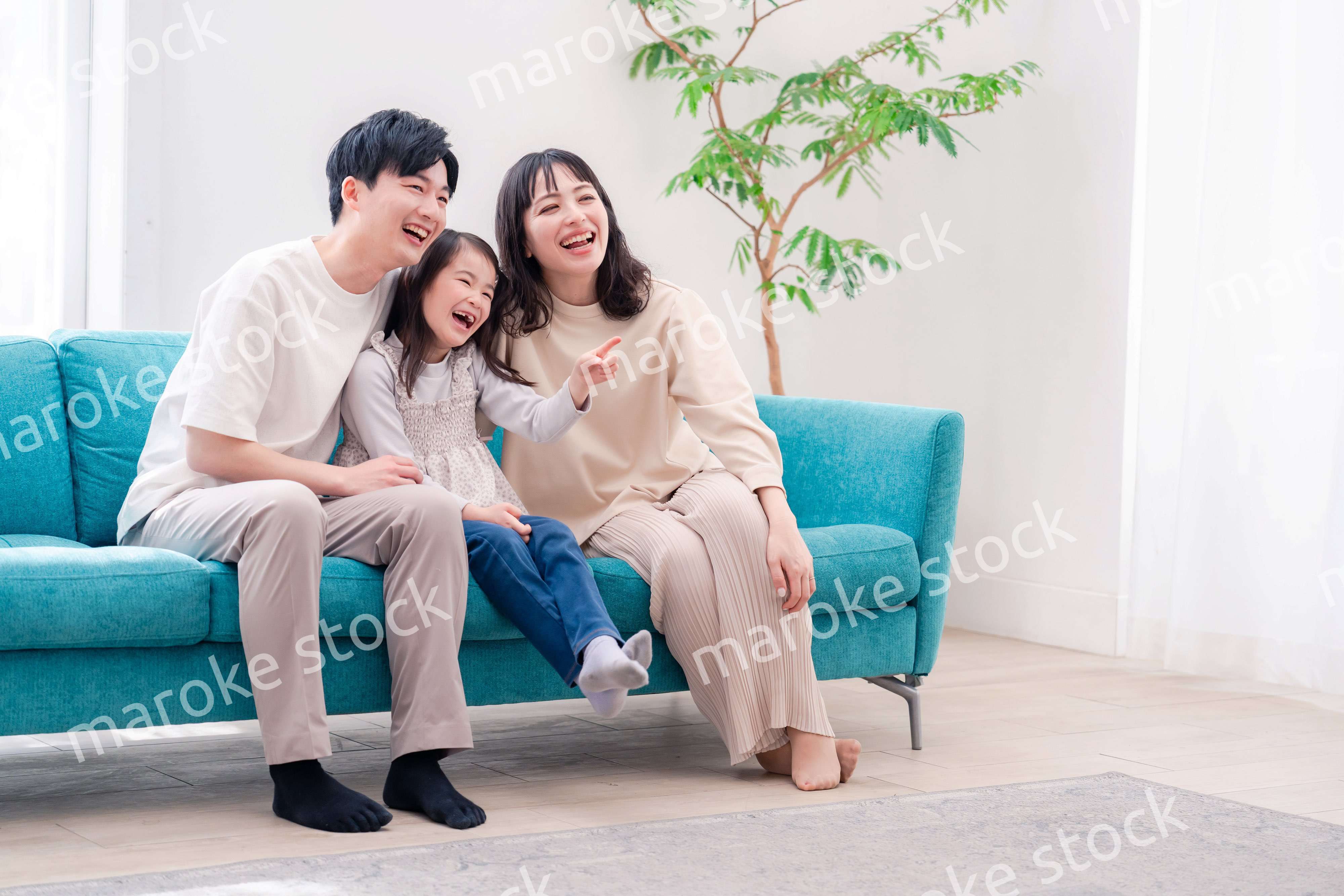 リビングでみんなでテレビを見るファミリー