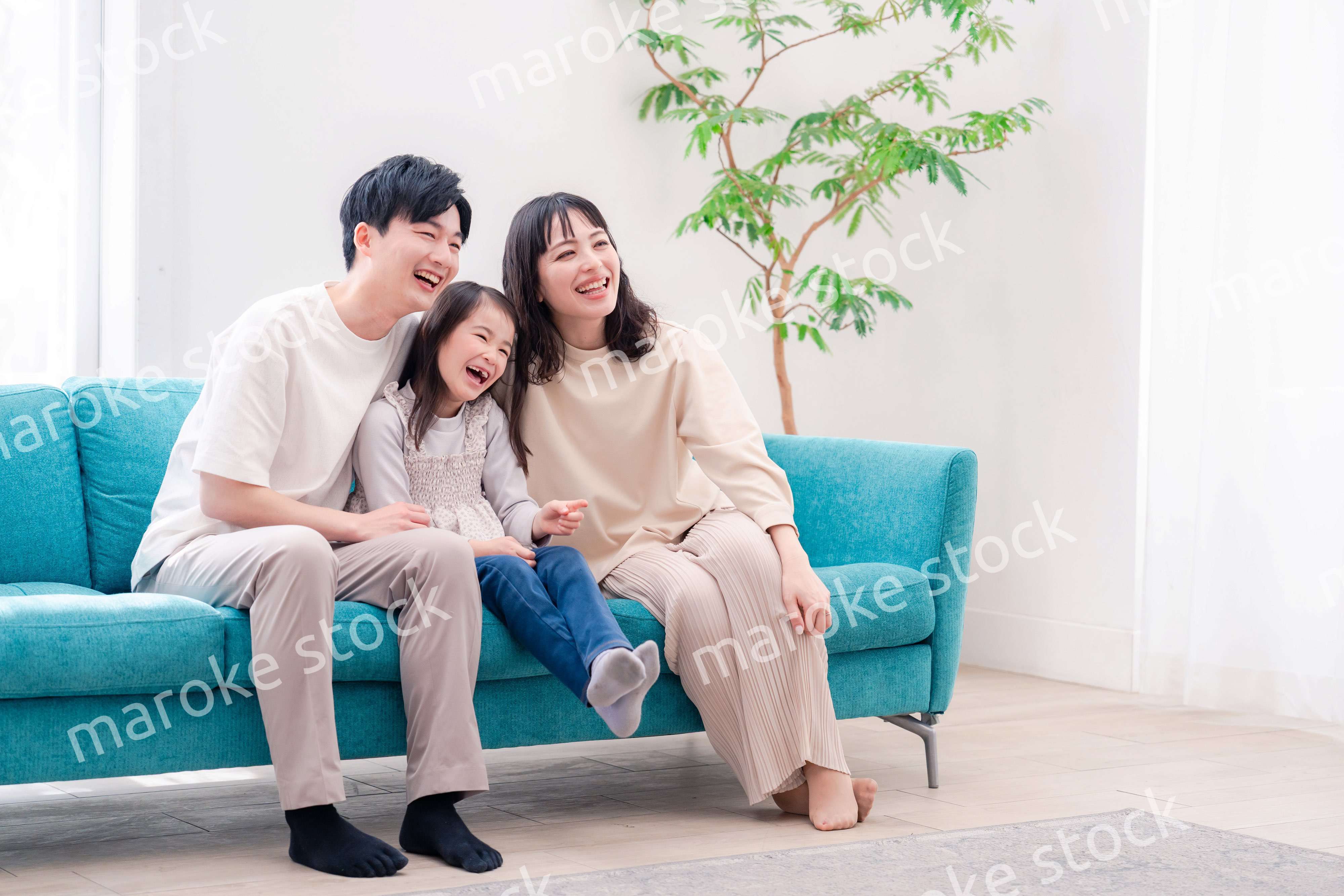 リビングでみんなでテレビを見るファミリー