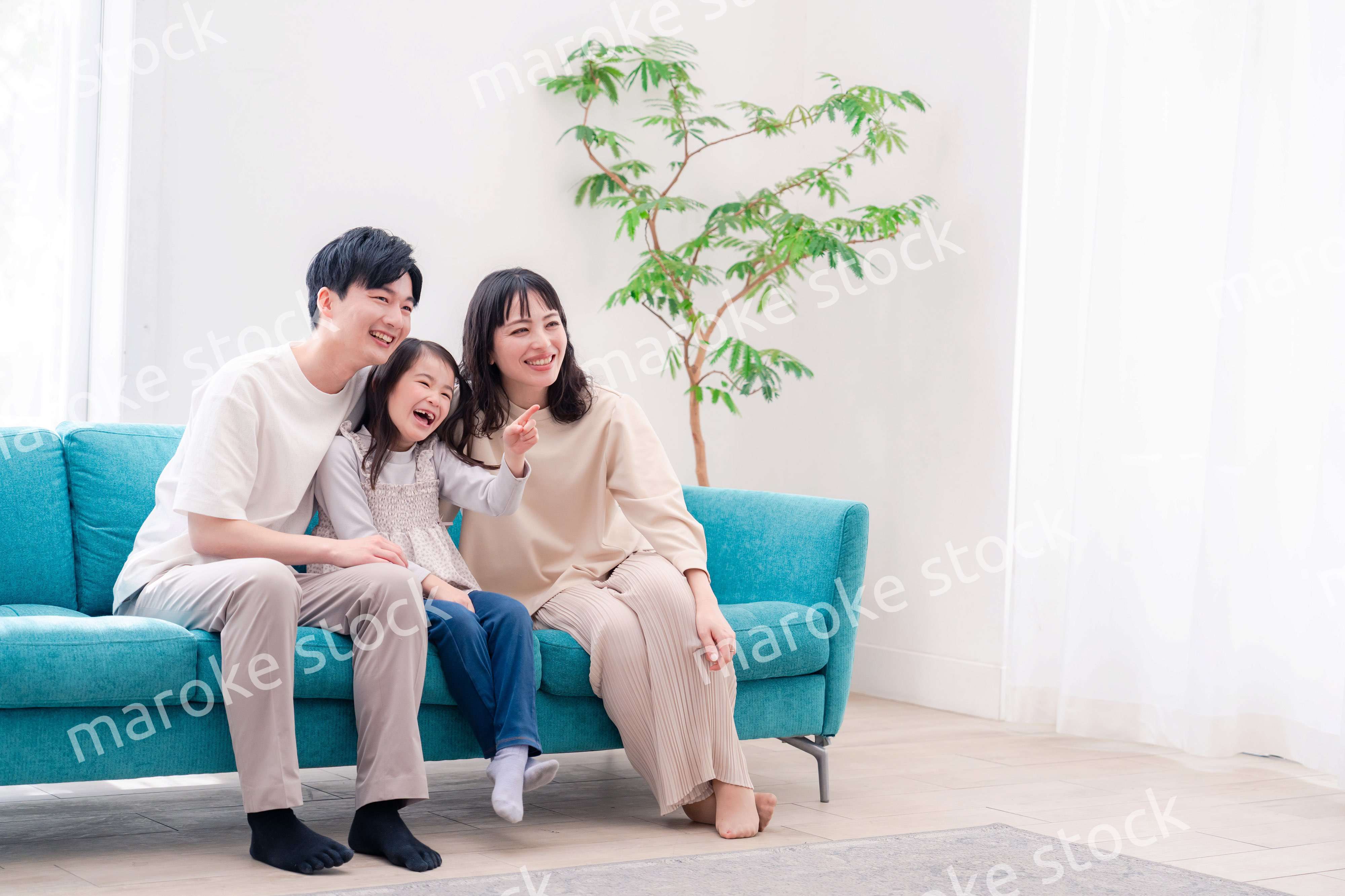 リビングでみんなでテレビを見るファミリー