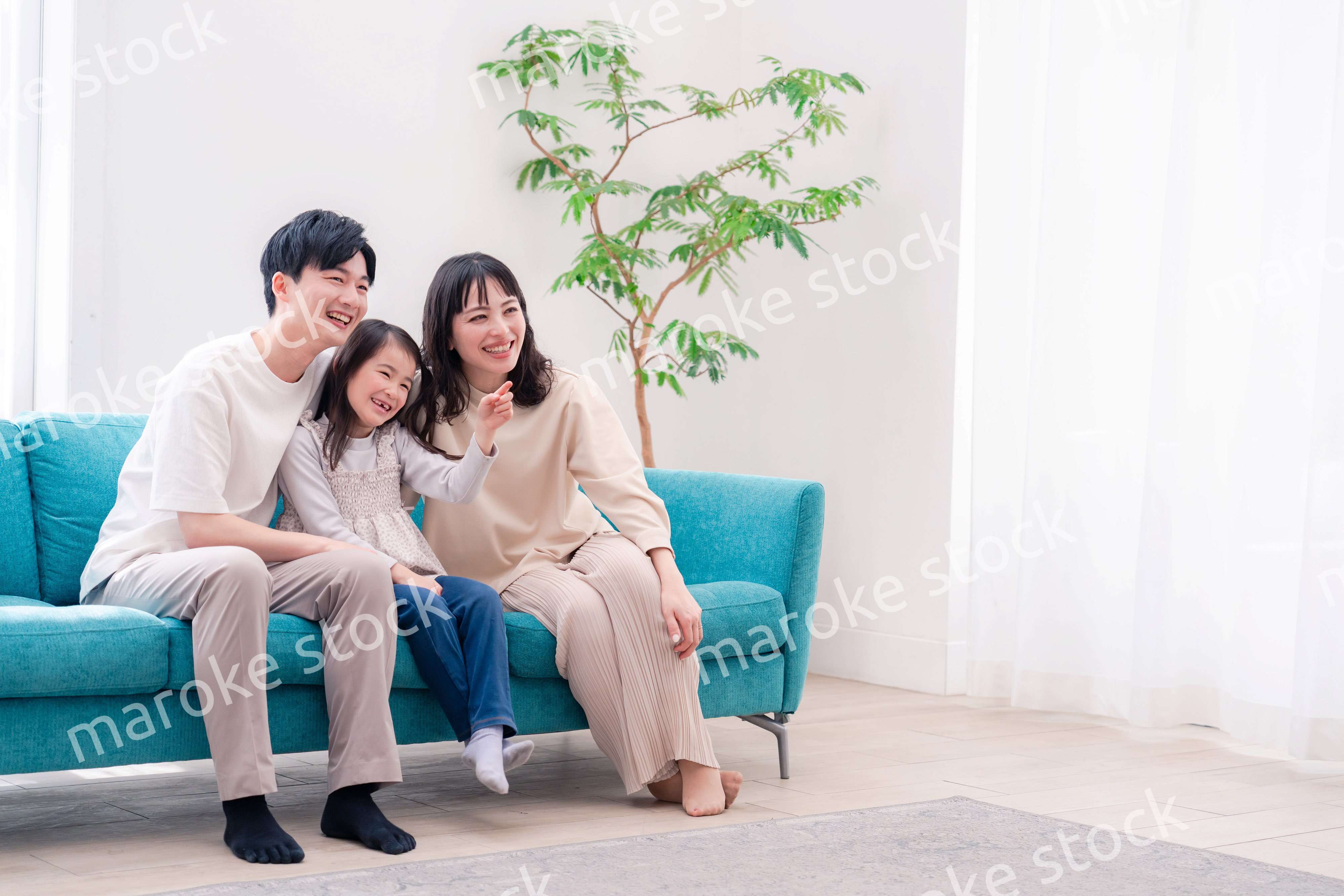 リビングでみんなでテレビを見るファミリー