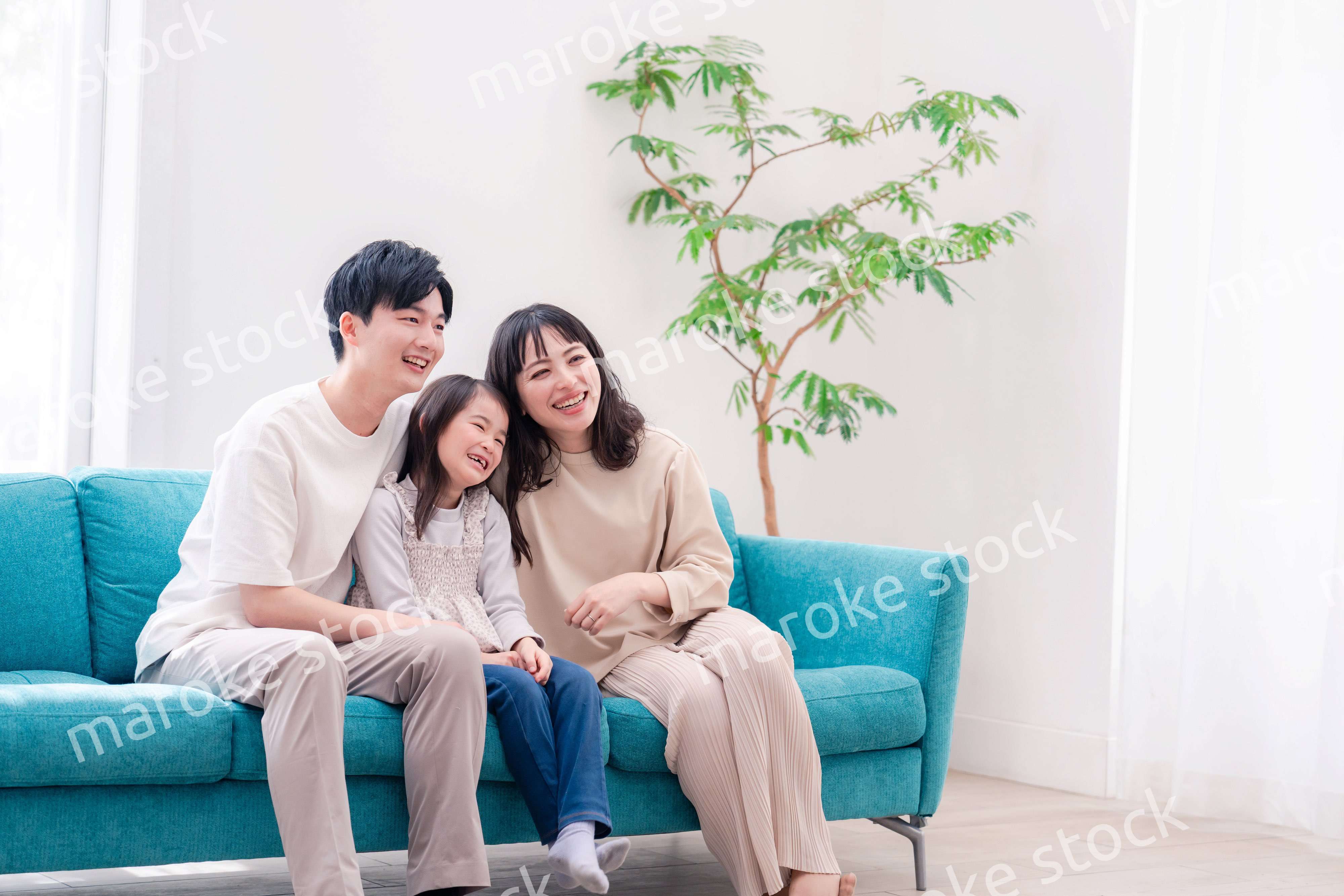 リビングでみんなでテレビを見るファミリー