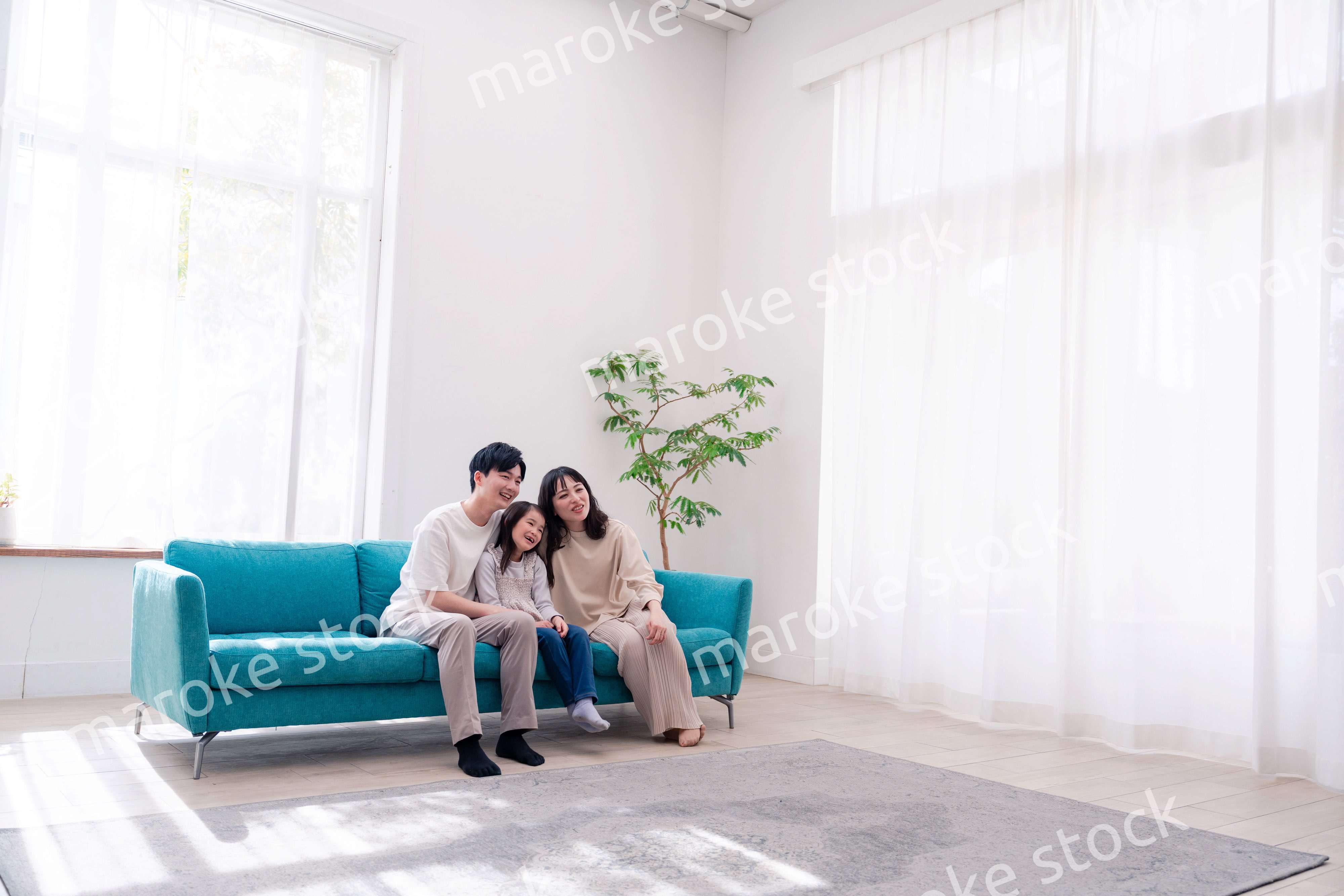 リビングでみんなでテレビを見るファミリー